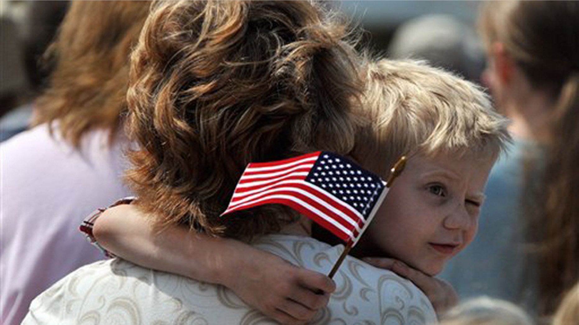 FILE -- Monday, May 28, 2012: Austin Bunyard, 5, squints in the bright sun as he watches veterans salute the American flag during a Memorial Day ceremony on the Rock Island Arsenal in Rock Island, Ill.