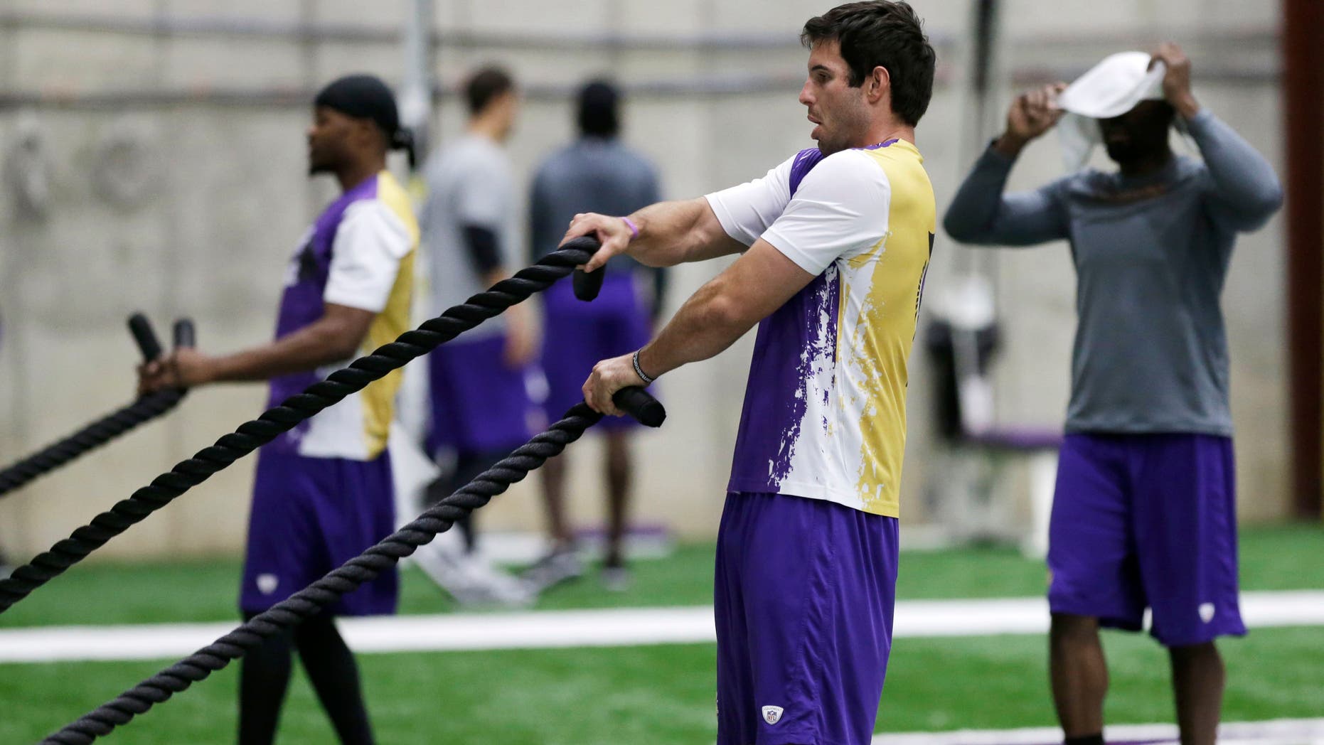 Minnesota Vikings quarterback Christian Ponder, right, and wide receiver Jerome SImpson, left, work on a rope pull exercise during conditioning workouts for the NFL football team, Wednesday, May 1, 2013 in Eden Prairie, Minn. Uncovering his head to watch is wide receiver Greg Jennings, right. (AP Photo/Jim Mone)