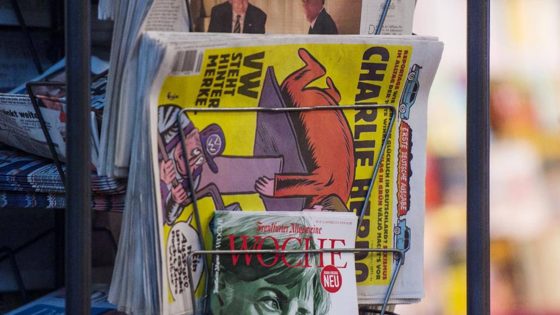 Copies of the French satirical magazine Charlie Hebdo sit at a newsagent's in Stuttgart, Germany, Thursday, Dec. 1, 2016. The first German edition went on sale on Thursday morning. (Lino Mirgeler/dpa via AP)