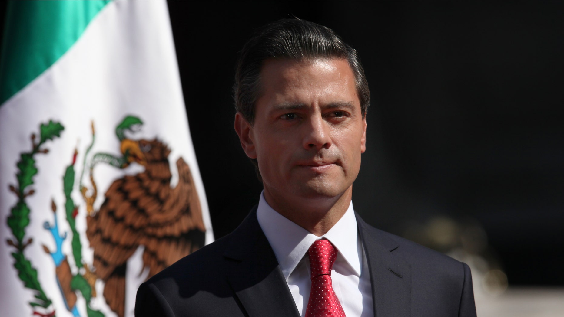 FILE - In this Nov. 3, 2014, file photo, Mexico's President Enrique Pena Nieto stands at attention as the national anthem of the UK and Mexico is played during an official visit by Britain's Prince Charles and his wife Camilla Duchess of Cornwall, at the National Palace in Mexico City. According to a report by a leading Mexican journalist, the private home of President Pena Nieto was built and is registered under the name of a company connected to a controversial high-speed rail contract that he abruptly canceled last week. The article did not specify what laws if any are broken by the president using a house registered under another name. (AP Photo/Marco Ugarte, File)