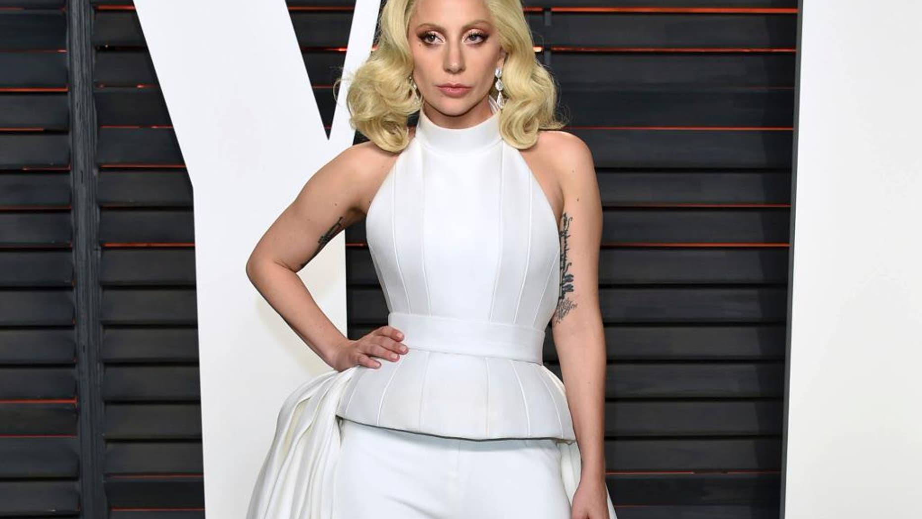 FILE - In this Feb. 28, 2016 file photo, Lady Gaga arrives at the Vanity Fair Oscar Party in Beverly Hills, Calif. Lady Gaga is choosing the intimacy of dive bars over arenas to showcase songs from her new album, "Joanne." She'll appear at a handful of bars beginning this week as a nod to the album's "raw Americana" vibe and where she got her start, Gaga and tour partner Bud Light announced Sunday, Oct. 2, 2016. (Photo by Evan Agostini/Invision/AP, File)
