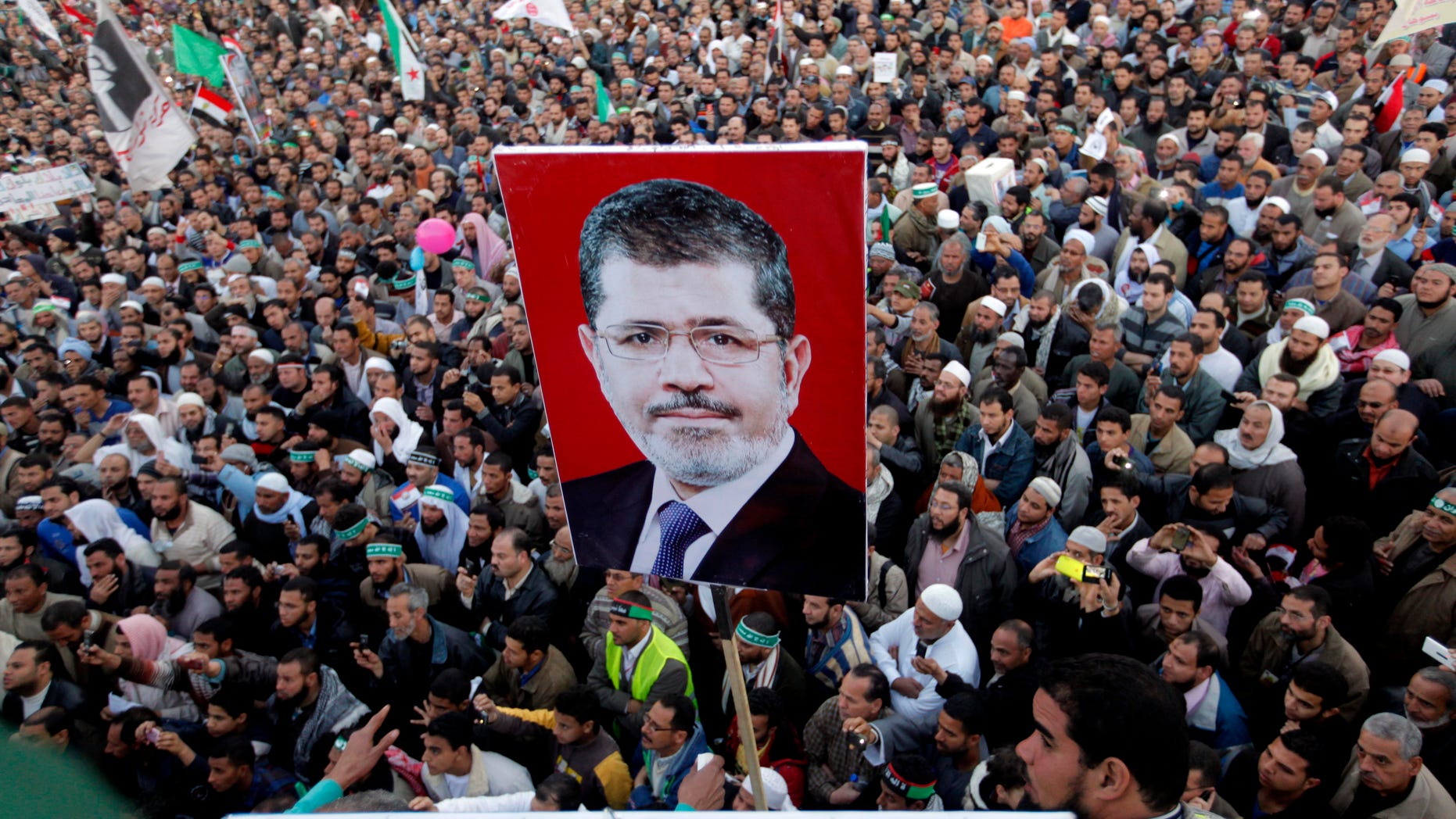 Thousands of Egyptian protesters shout slogans supporting Islamist President Mohammed Morsi, his poster at center, during a rally outside Cairo University in Cairo, Egypt, Friday, Feb. 15, 2013. Several thousand mostly hard-line Islamists protested in Cairo on Friday against a recent wave of violent anti-government protests, while liberal activists staged a smaller demonstration across town to call for accountability and justice from the country's leaders.(AP Photo/Amr Nabil)