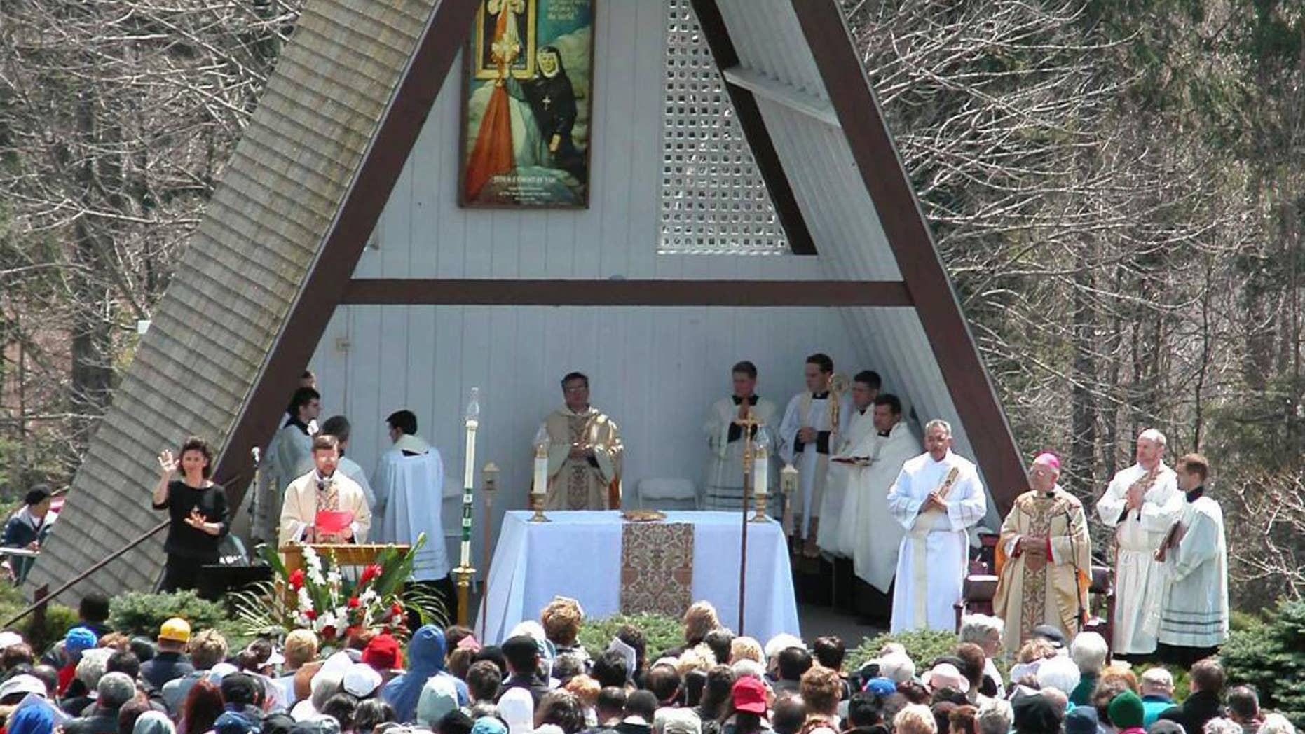 FILE- In this April 27, 2003, file photo, people attend the Mass officiated by Bishop Thomas L. Dupre, third from right, at the National Shrine of The Divine Mercy in Stockbridge, Mass. Dupre, the first Roman Catholic bishop in the United States to be indicted on a sexual-abuse claim during a flood of abuse accusations against church officials, died Friday, Dec. 30, 2016, according to the Diocese of Springfield. Dupre was 83. (AP Photo/Alan Solomon, File)