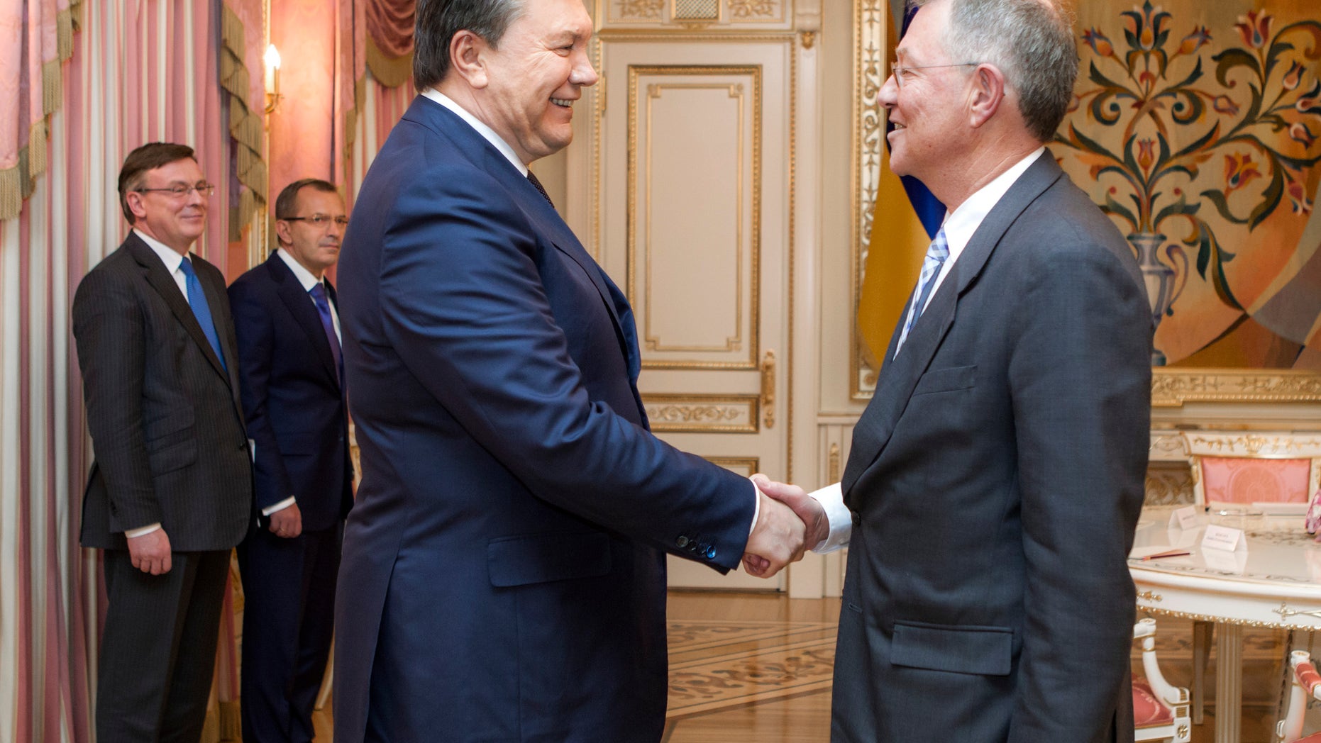 Ukraine's President Viktor Yanukovych, left, greets United Nations Special Coordinator Robert Serry prior their talks in Kiev, Ukraine, Wednesday, Jan. 29, 2014. Ukraine's parliament discussed an amnesty Wednesday for those arrested during weeks of protests in the crisis-torn country — but some of the possible conditions attached to it would be unacceptable to the opposition. (AP Photo/Mykhailo Markiv, Pool)