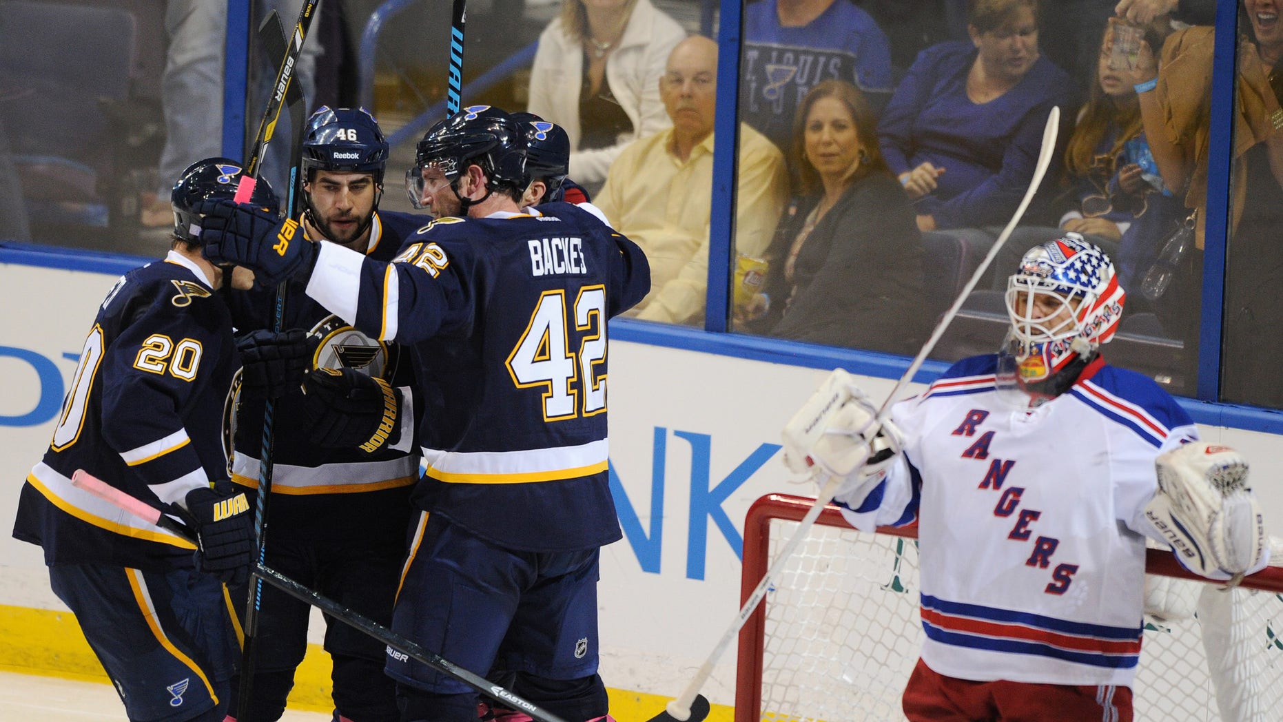 St. Louis Blues' David Backes (42) celebrates his goal with teammates Alexander Steen (20) and Roman Polak (46), of Czech Republic, as New York Rangers' goalie Martin Biron, right, looks away during the second period of an NHL hockey game on Saturday, Oct. 12, 2013, in St. Louis. (AP Photo/Bill Boyce)