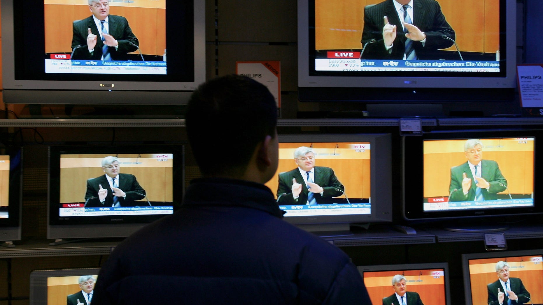 HAMBURG, GERMANY - APRIL 25: A man watches TVs on sale in Hamburg show German Foreign Minister Joschka Fischer testifying live in front of the visa investigation committee on April 25, 2005 in Berlin, Germany. The committee, taking place in Berlin, is investigating allegations that an overly generous policy of granting visa applications at the German embassy in Kiev allowed thousands of people to enter the European Union, much to the benefit of people smugglers and other criminal gangs. (Photo by Andreas Rentz/Getty Images)