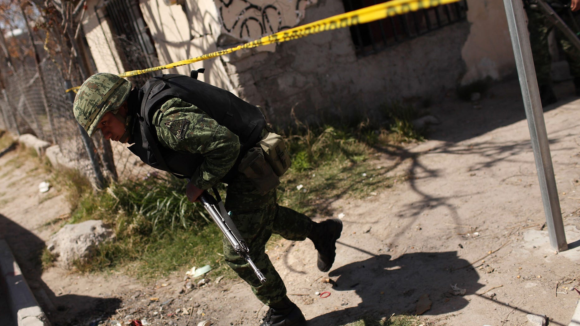 JUAREZ, MEXICO - MARCH 24: Members of the Mexican military police keep guard at the scene of the murder of two women aged 17 and 21 March 24, 2010 in Juarez, Mexico. Secretary of State Hillary Rodham Clinton, Defense Secretary Robert Gates, and Homeland Security Secretary Janet Napolitano all visited Mexico yesterday for discussions centered on Mexico's endemic drug-related violence. The border city of Juarez, Mexico has been racked by violent drug-related crime recently and has quickly become one of the most dangerous cities in the world in which to live. As drug cartels have been fighting over ever-lucrative drug corridors along the United States border, the murder rate in Juarez has risen to 173 slayings for every 100,000 residents. President Felipe Calderon's strategy of sending 7000 troops to Juarez has not mitigated the situation. With a population of 1.3 million, 2,600 people died in drug-related violence last year and 500 so far this year, including two Americans recently who worked for the U.S. Consulate and were killed as they returned from a child's party. (Photo by Spencer Platt/Getty Images)