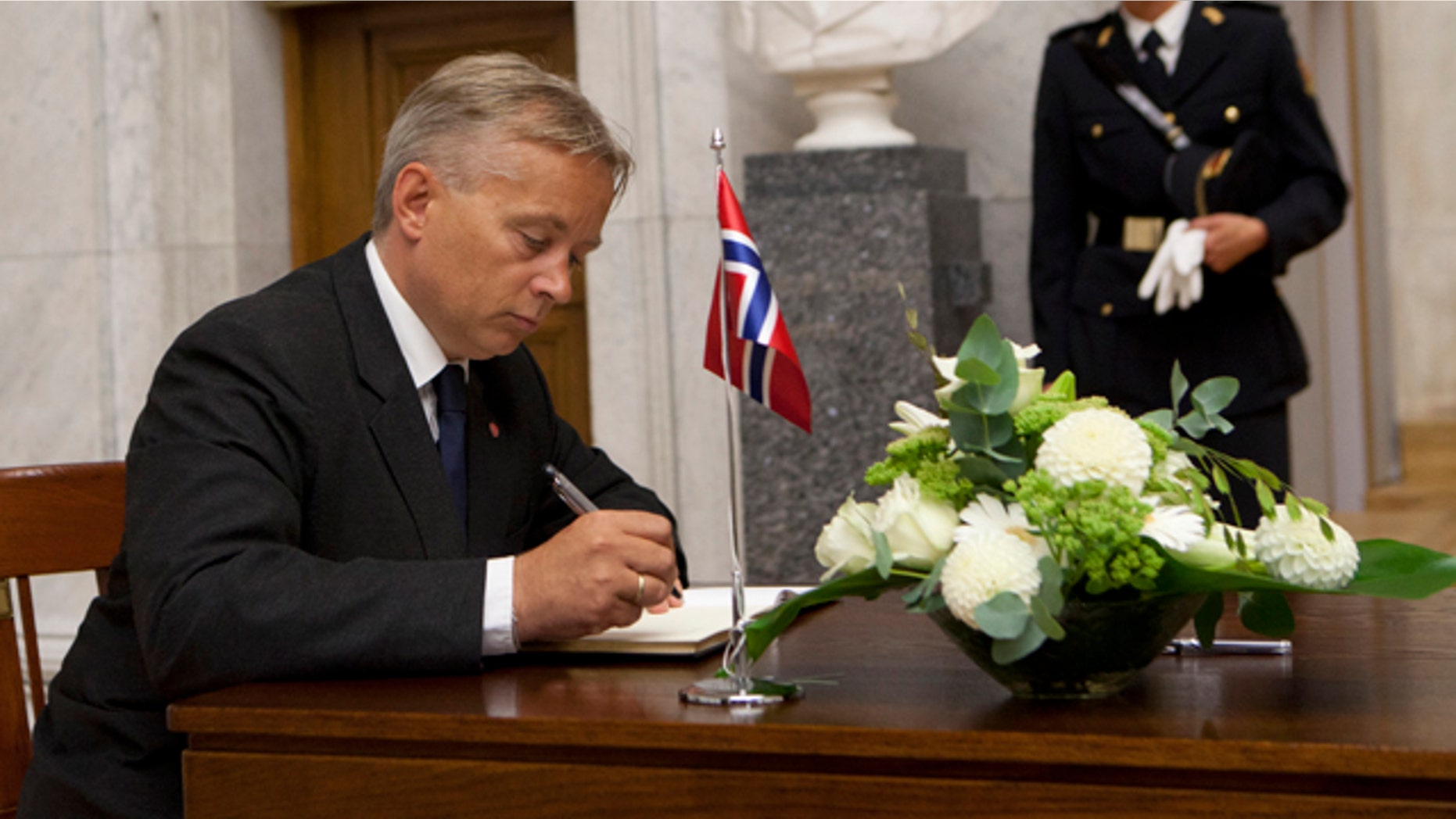 July 26: Norwegian minister of Justice, Knut Storberget, signs a protocol of condolence for the victims of last Friday's bomb attack and shooting massacre, in the Grand Hall of Oslo University.