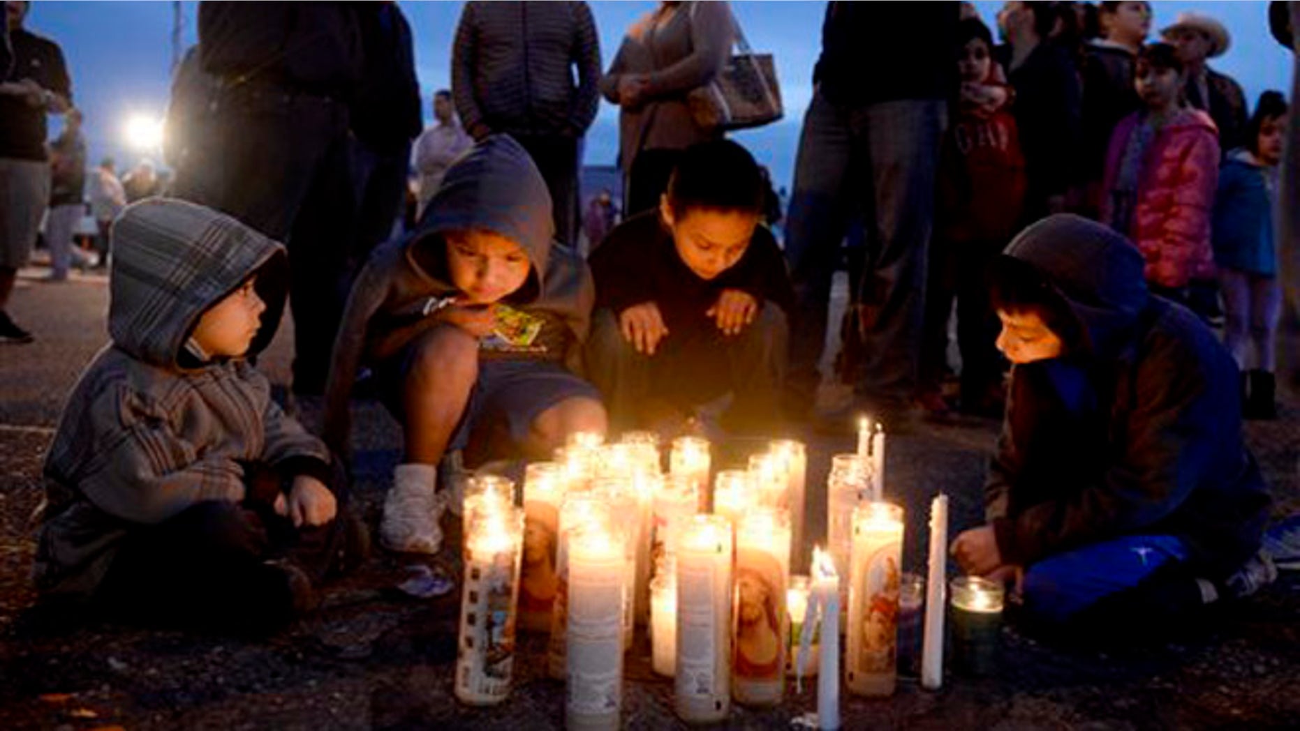 Pasco, Wash., residents, from left foreground to right, Angel Morgan, 5, and his brother Jose Morgan, 6, as well as Alex Gonzalez, 4, and his brother Angel Gonzalez, 8, gather around a candlelit vigil Wednesday, Feb. 11, 2015, in memory of Antonio Zambrano-Montes who was fatally shot by police after a confrontation on Tuesday. (AP Photo/The Tri-City Herald, Sarah Gordon) LOCAL TELEVISION OUT; LOCAL RADIO OUT KONA
