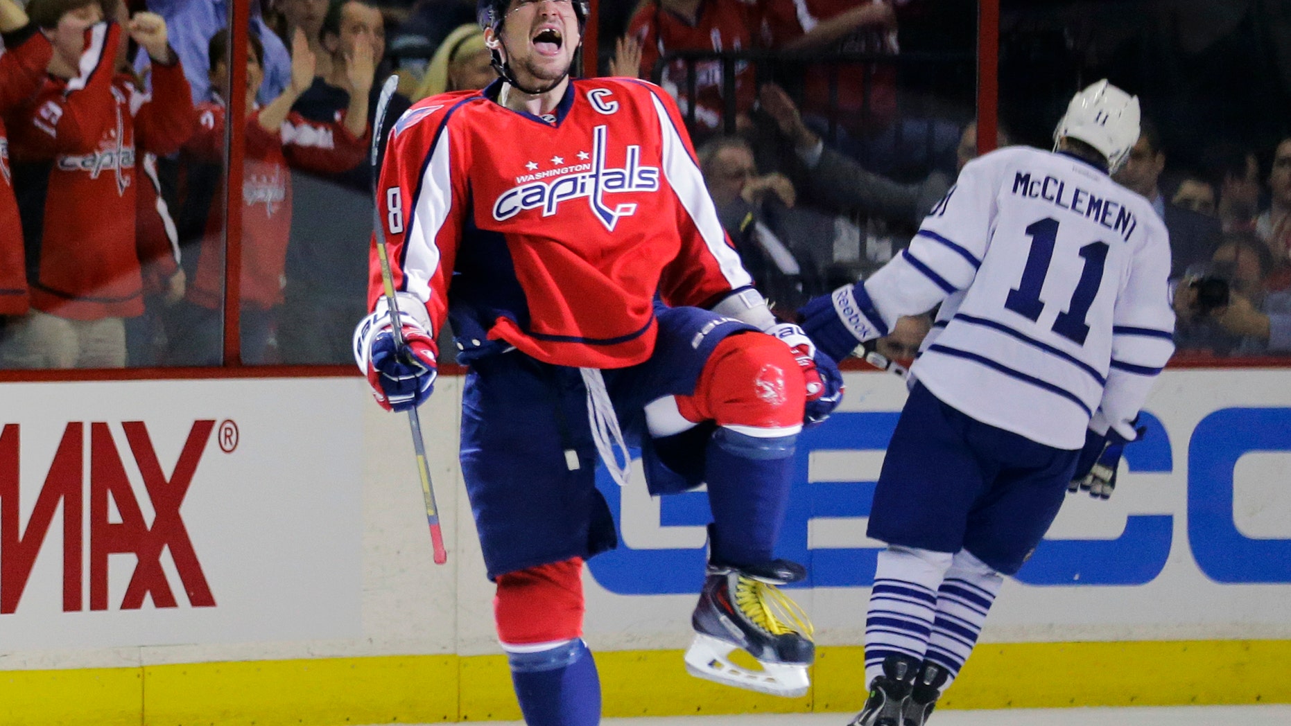 Washington Capitals left wing Alex Ovechkin (8), from Russia, celebrates his goal as Toronto Maple Leafs center Jay McClement (11) skates behind in the second period of an NHL hockey game Tuesday, April 16, 2013 in Washington. (AP Photo/Alex Brandon)