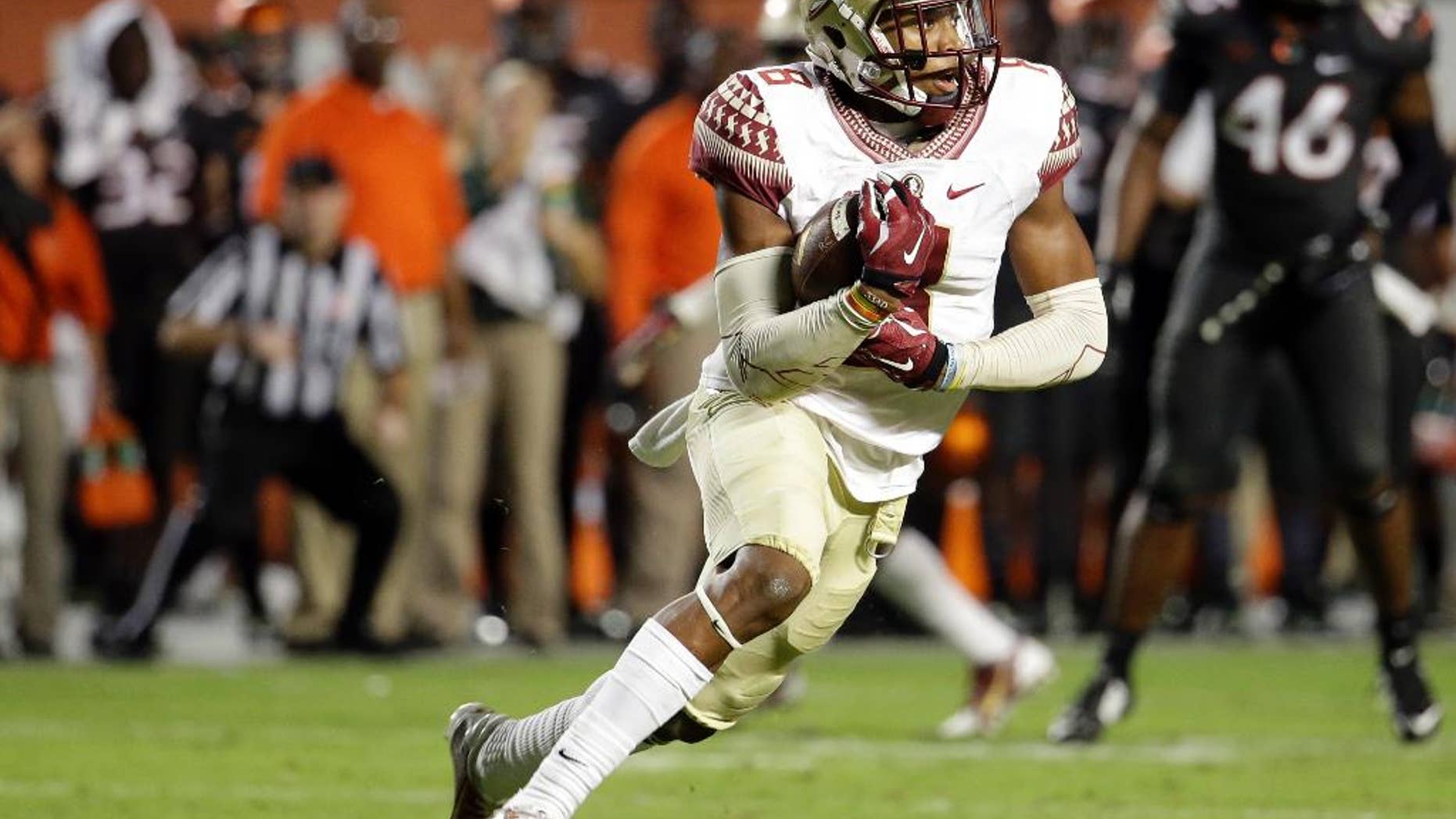Florida State defensive back Jalen Ramsey runs with the ball after intercepting a pass thrown by Miami quarterback Brad Kaaya in the second half an NCAA college football game, Saturday, Nov. 15, 2014, in Miami Gardens, Fla. Florida State defeated Miami 30-26. (AP Photo/Lynne Sladky)