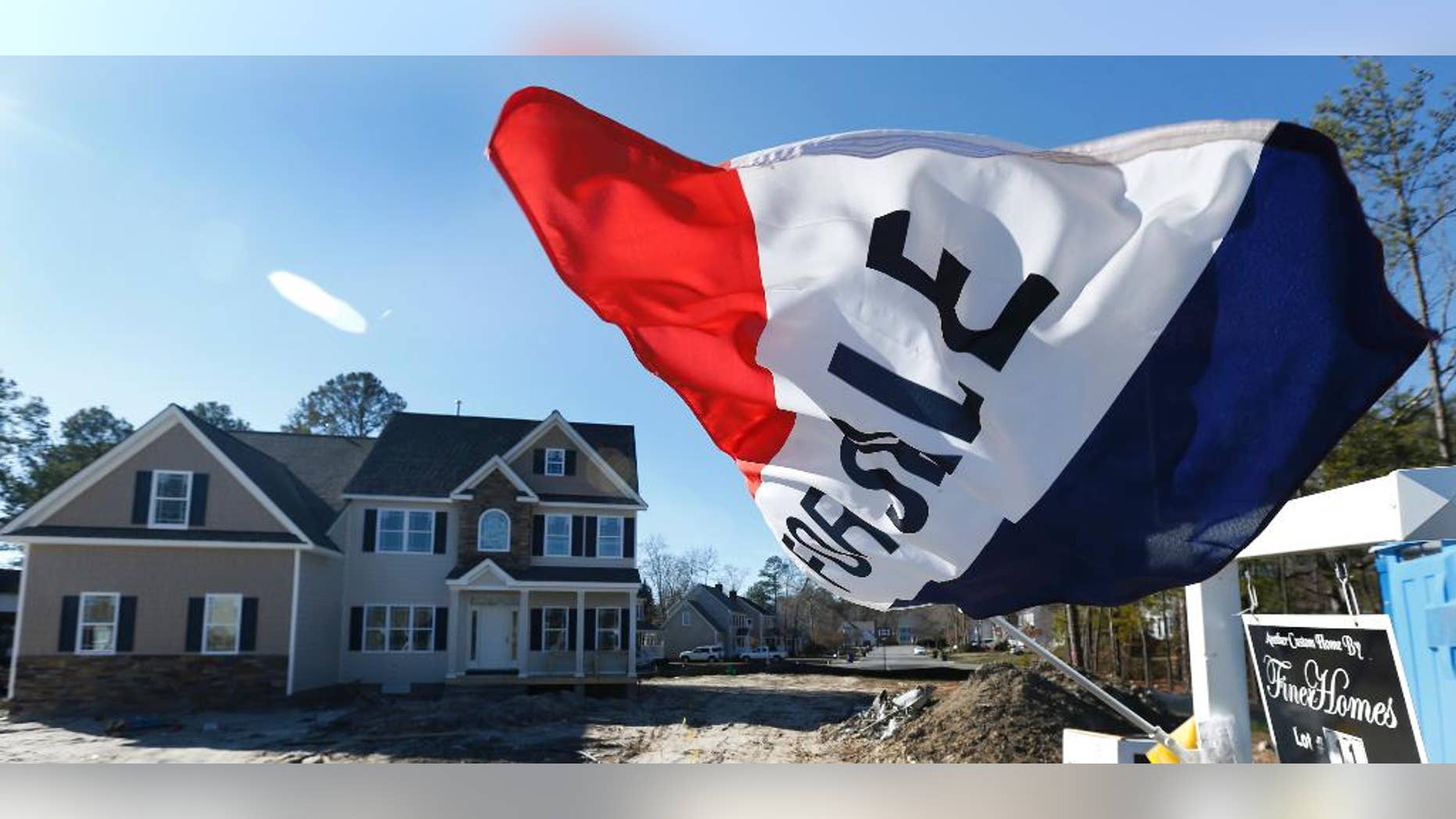 In this Thursday, Jan. 8, 2015 photo, a flag flaps in the breeze in front of a new home for sale in Richmond, Va. The Commerce Department reports on sales of new homes for December on Tuesday, Jan. 27, 2015. (AP Photo/Steve Helber)