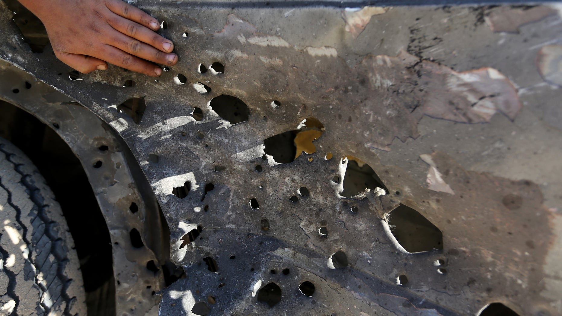 Palestinian Hamas security officers and civilians inspect the debris of a damaged motorcycle after an Israeli airstrike in Deir al-Balah, central Gaza Strip, Sunday, Feb. 9, 2014. The Israeli military says it has carried out an airstrike in the Gaza Strip targeting a Palestinian militant, Abdallah Kharti, who it says is affiliated with the Popular Resistance Committees militant group, and that Kharti planned and carried out numerous rocket attacks on Israel. A Gaza health official says the targeted man was critically wounded. (AP Photo/Hatem Moussa)