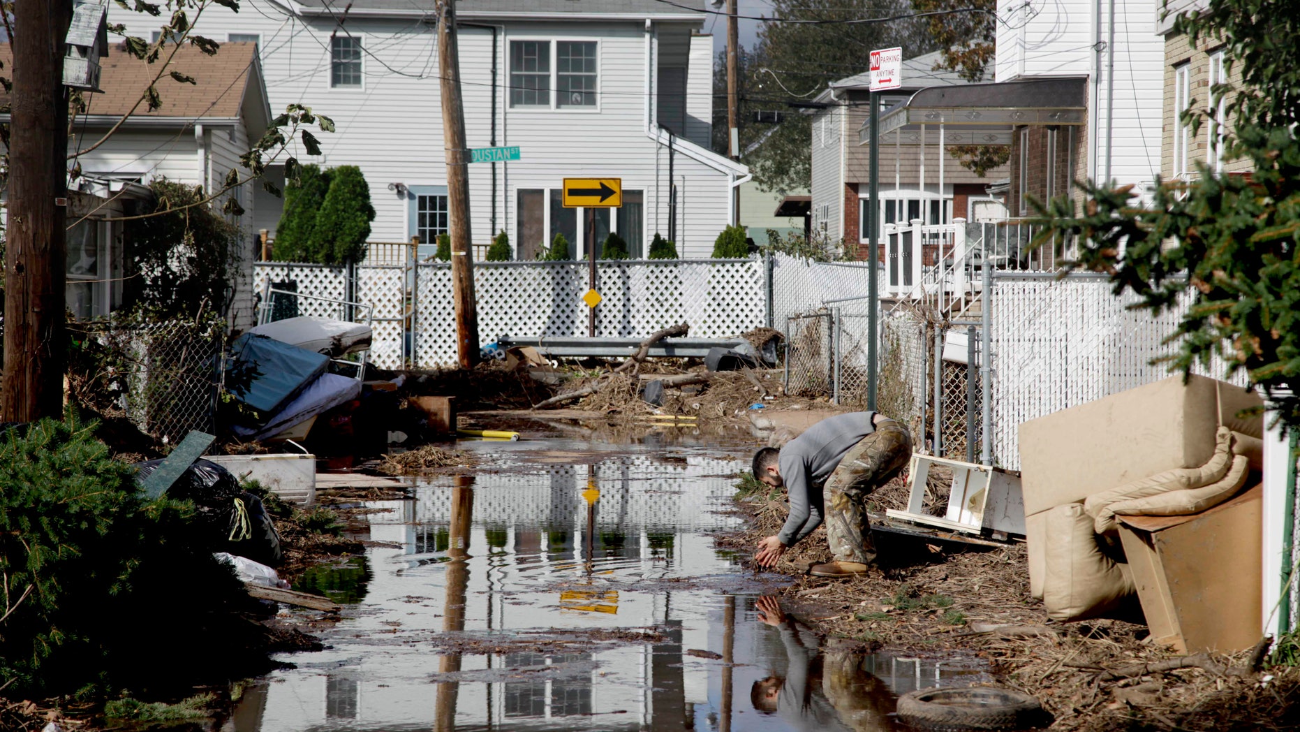 Nov. 2, 2012: A man rinses his hands in flood water while cleaning out a house in a hard-hit neighbor hood in Staten Island, N.Y.
