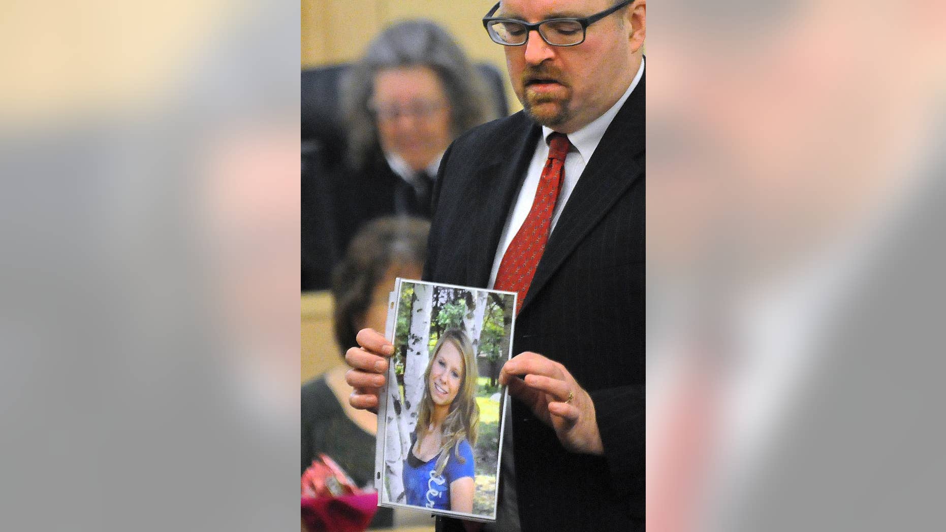 FILE - In this Feb. 23, 2015 file photo, Assistant Attorney Gen. Donald Macomber hold up a picture of Nichole Cable during opening arguments on the first day of Kyle Dube's trial in Bangor, Maine, where he was charged in Cable's 2013 kidnapping and murder. After less than an hour of deliberation, a jury convicted Dube Friday, March 6, 2015, of using a bogus Facebook profile to lure Cable to her death in a botched plot to look like a hero. (AP Photo/The Bangor Daily News, Gabor Degre, Pool, File)