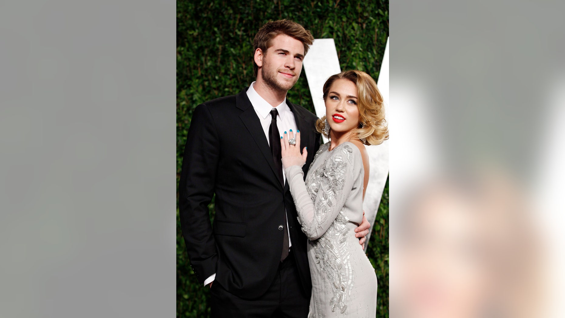 February 26, 2012. Singer Miley Cyrus (R) and actor Liam Hemsworth pose as they arrive at the 2012 Vanity Fair Oscar party in West Hollywood, California.