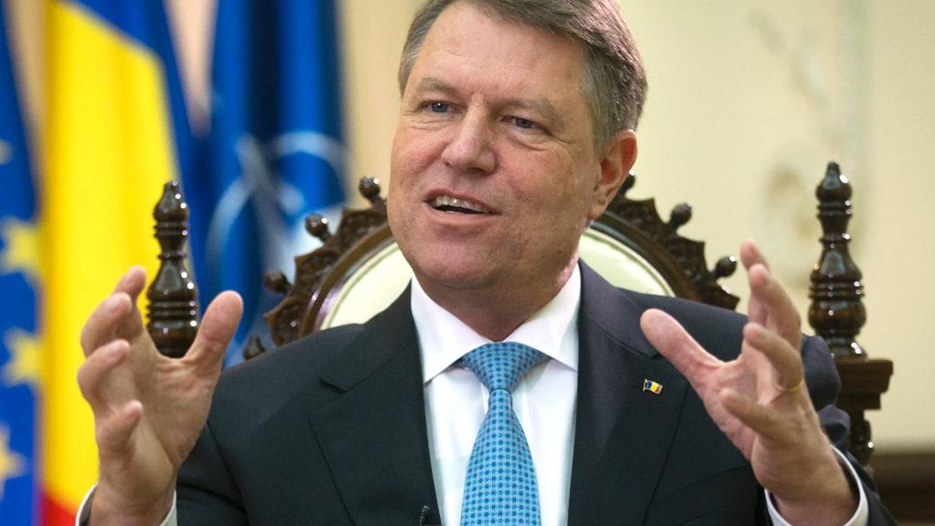 Romania's president Klaus Iohannis gestures during an interview with the Associated Press at the Cotroceni Palace in Bucharest, Romania, Wednesday, Feb. 8, 2017. President Iohannis said massive street protests had successfully toppled a government initiative dilute the ant-corruption drive, but warned that the fight against graft was an ongoing process. (AP Photo/Darko Bandic)