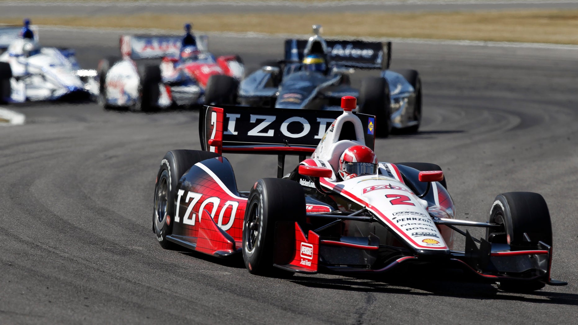 A.J. Allmendinger (2) leads a pack of cars into Turn 17 during the IndyCar Series Grand Prix of Alabama auto race in Birmingham, Ala., Sunday, April 7, 2013. (AP Photo/Butch Dill)