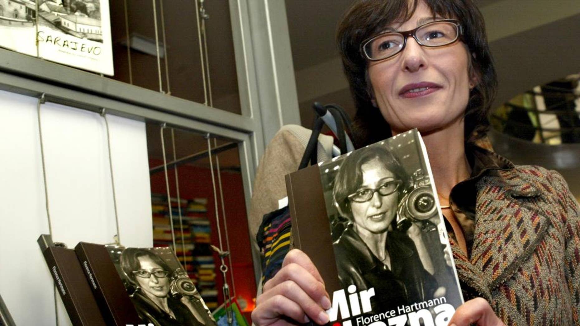 FILE - In this Tuesday, Nov. 13, 2007 file photo, Florence Hartmann, ex-spokeswoman for the Chief Prosecutor of the Hague-based International Criminal Tribunal for the former Yugoslavia (ICTY), presents her book Peace and Punishment in Sarajevo. Florence Hartmann, U.N. spokeswoman-turned-whistleblower, is behind bars at the same prison complex with many of the war criminals she spent her career trying to expose, her lawyer said Monday March 28, 2016, as journalists and victims’ advocates rallied to her side. (AP Photo/Hidajet Delic, File)