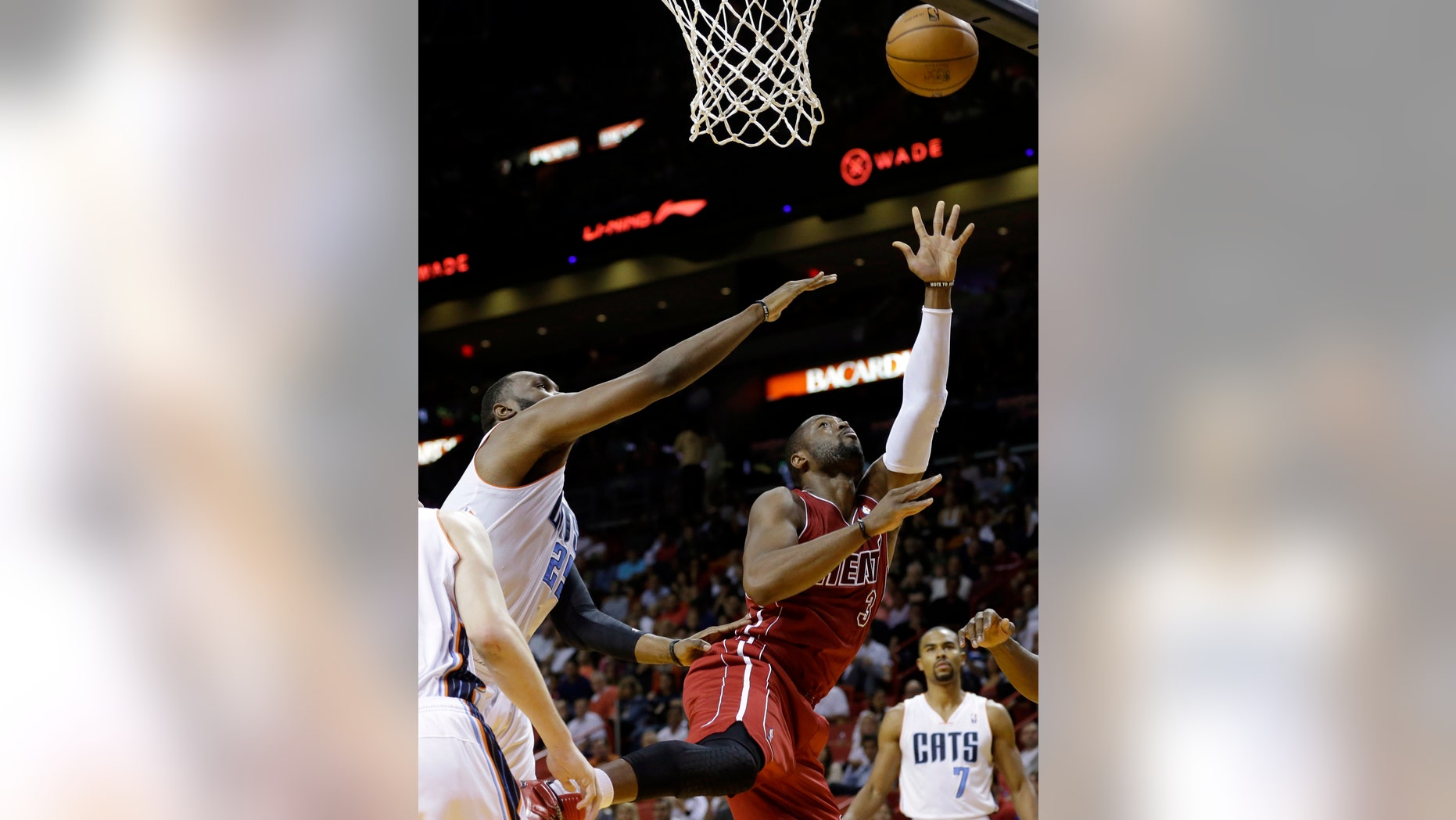 Miami Heat's Dwyane Wade (3) shoots over Charlotte Bobcats' Al Jefferson, left, during the first half of an NBA basketball game Sunday, Dec. 1, 2013, in Miami. (AP Photo/Lynne Sladky)