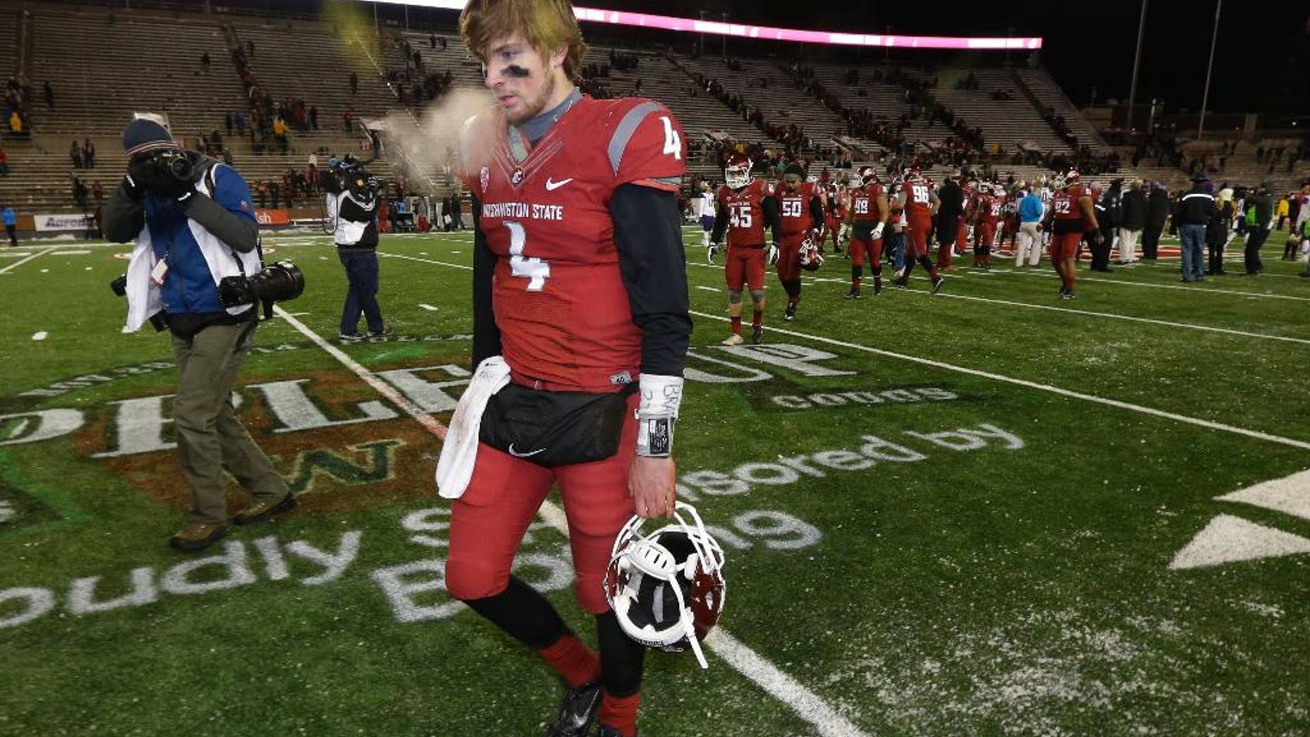 Washington State quarterback Luke Falk walks off the field, Saturday, Nov. 29, 2014, in Pullman, Wash., after Washington defeated Washington State 31-13 in an NCAA college football game. (AP Photo/Ted S. Warren)