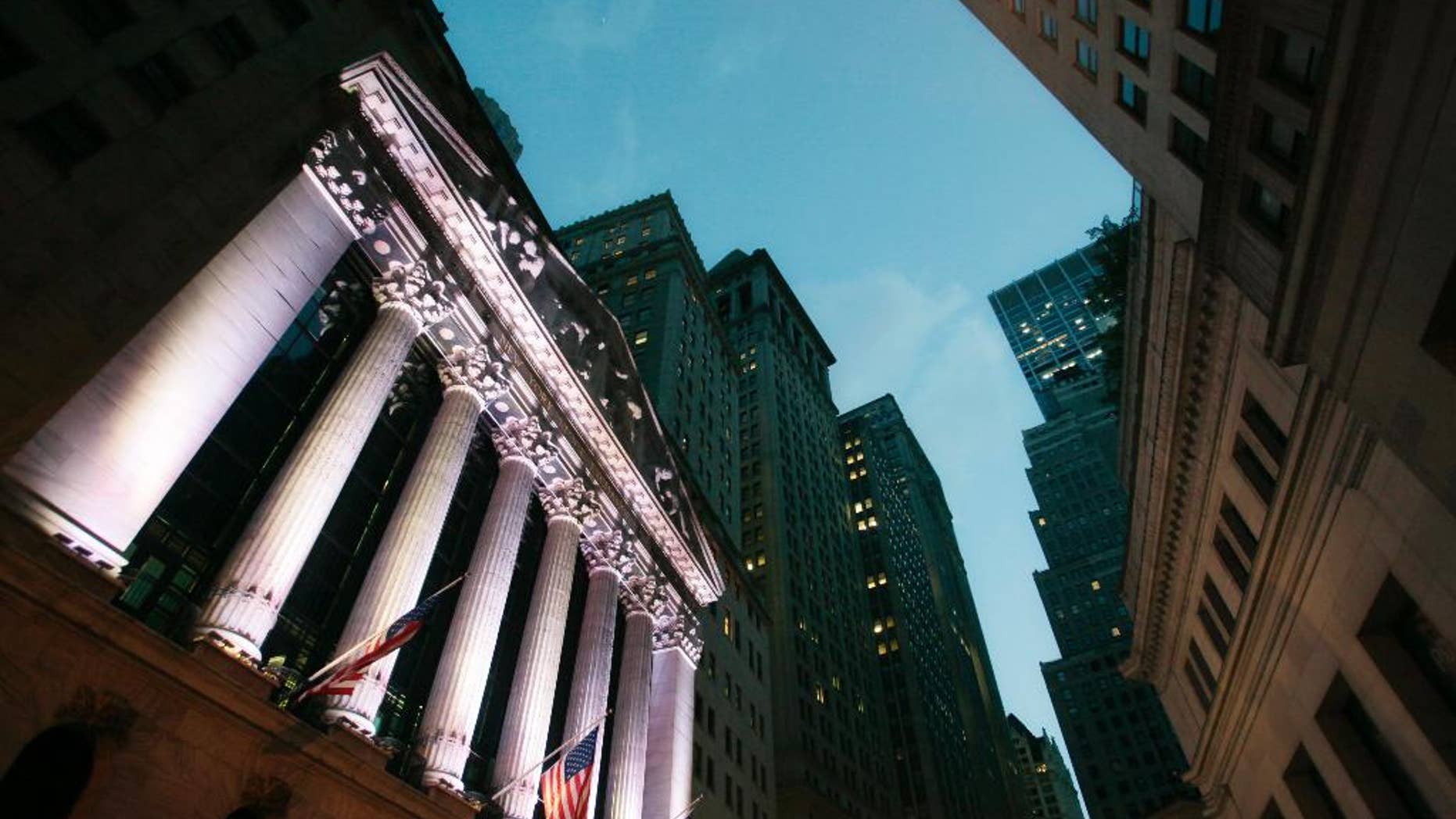 FILE - In this Oct. 8, 2014 file photo, American flags fly in front of the New York Stock Exchange, in New York. Stocks are little changed in early trading Monday, Nov. 3, 2014, as investors brace for a busy week of news. (AP Photo/Mark Lennihan, File)