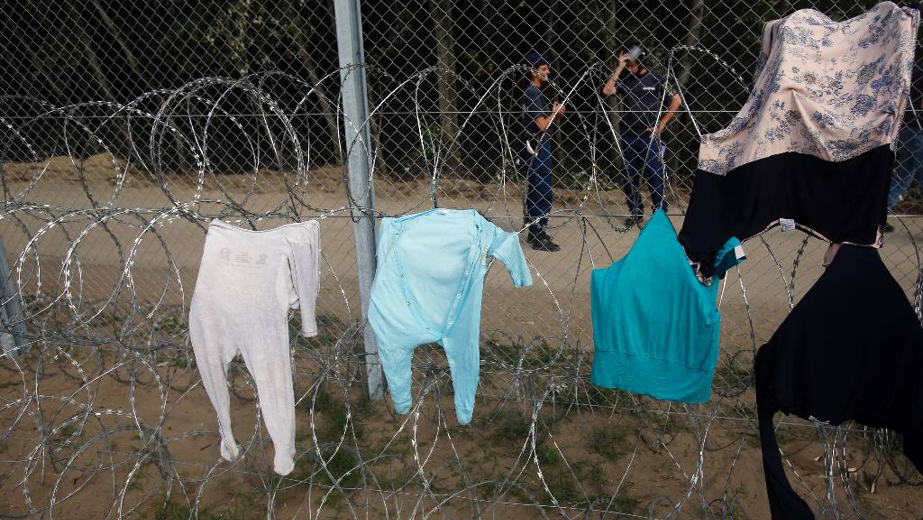 Clothes are placed on a fence to dry at the Horgos border crossing into Hungary, near Horgos, Serbia, Wednesday, Sept. 16, 2015. Small groups of migrants continued to sneak into Hungary on Wednesday, a day after the country sealed its border with Serbia and began arresting people trying to breach the razor-wire barrier, while a first group arrived in Croatia seeking another way into the European Union. (AP Photo/Darko Vojinovic)