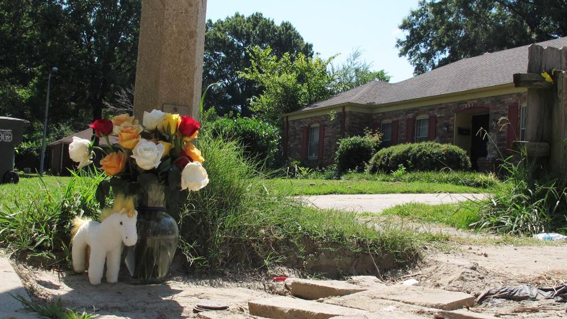 A makeshift memorial rests on the sidewalk Monday, Aug. 3, 2015, at the location where Memphis, Tenn., Police Officer Sean Bolton was fatally shot. Tremaine Wilbourn, the ex-con accused of killing the Memphis Police Officer turned himself into federal authorities Monday, after a two-day manhunt. (AP Photo/Adrian Sainz)