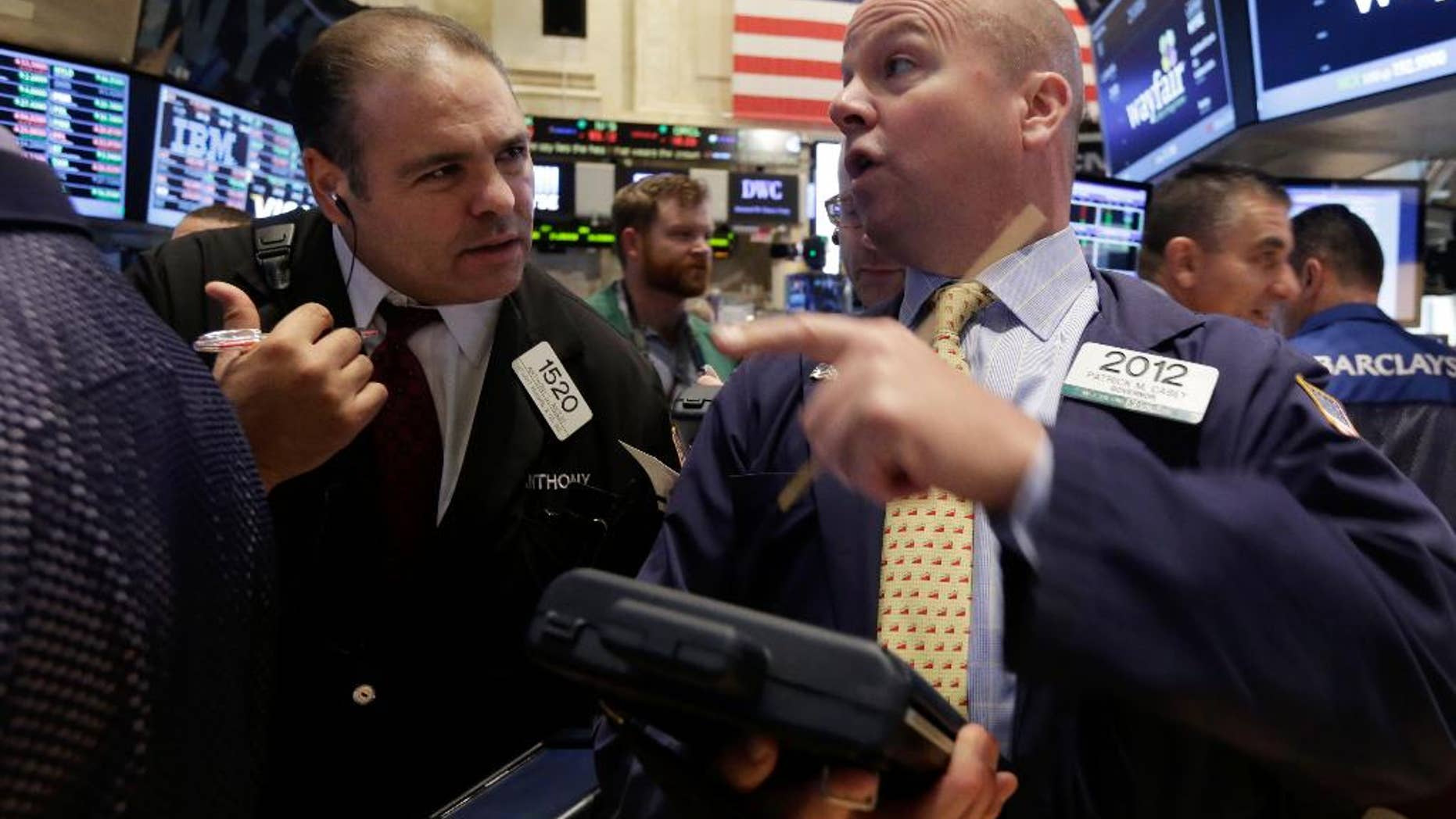 Traders Anthony Riccio, left, and Patrick Casey work on the floor of the New York Stock Exchange, Thursday, Oct. 2, 2014. U.S. markets were mostly flat in early trading Thursday, follow a sell-off the day before, as U.S. investors had little reaction to comments from European Central Bank President Mario Draghi, who announced new economic stimulus measures for the continent. (AP Photo/Richard Drew)