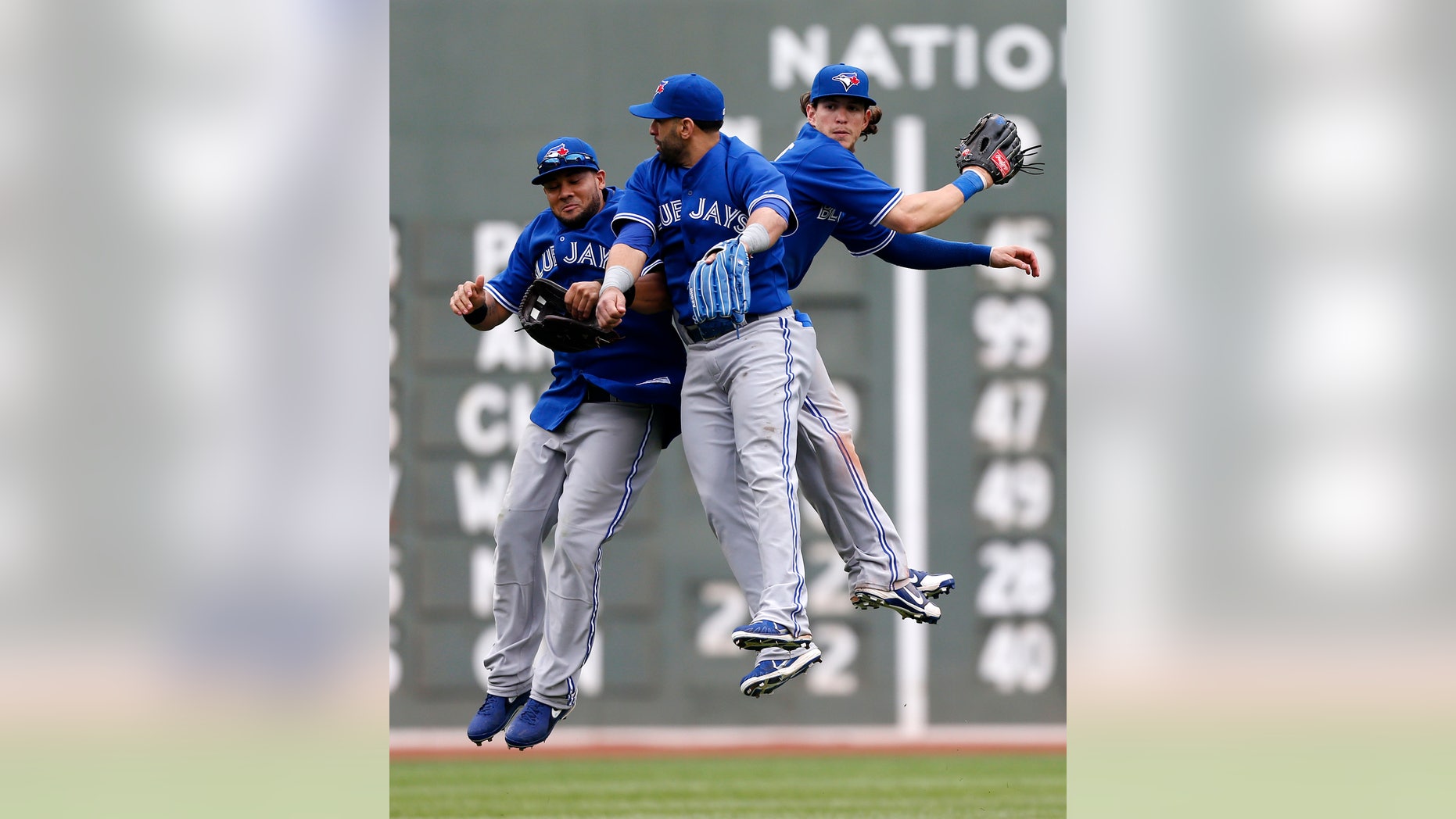 Toronto Blue Jays', from left, Melky Cabrera, Jose Bautista and Colby Rasmus celebrate after defeating the Boston Red Sox 3-2 in a baseball game in Boston, Saturday, May 11, 2013. (AP Photo/Michael Dwyer)