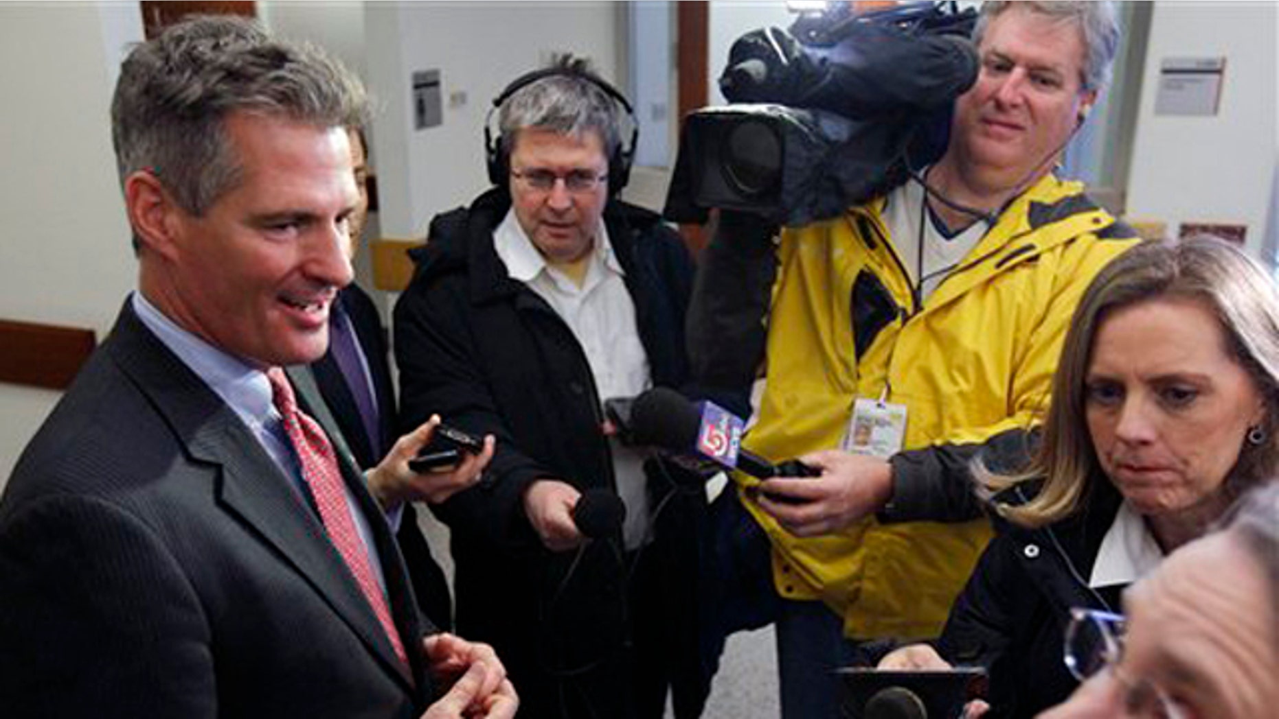 FILE: Then-Sen. Scott Brown talks with members of the media during a tour of Boston Police headquarters in Boston.
