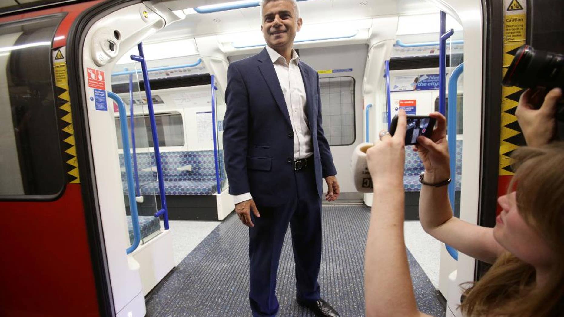 Mayor of London Sadiq Khan poses for the media on a Victoria line tube train carriage at Brixton Underground station in London during the launch of London's Night Tube Saturday, Aug. 20, 2016. The London Underground introduced limited overnight service Saturday, a move city leaders hope will make the British capital a truly 24-hour city and bolster the local economy. (Yui Mok/PA via AP)
