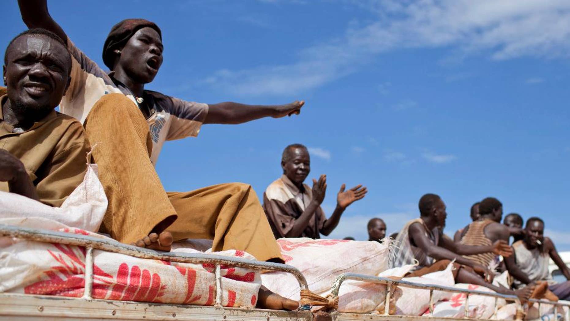 FILE - In this Sunday Sept. 16, 2012 file photo, South Sudanese men sing and clap as they ride on the truck carrying WFP food supplies to a warehouse, in Yida camp, South Sudan. The World Food Program said Friday April 14, 2017 it is "horrified" to learn that three of its South Sudan workers were killed this week in violence in the western town of Wau, as the country's civil war continues under warnings of possible genocide. (AP Photo/Mackenzie Knowles-Coursin, File)