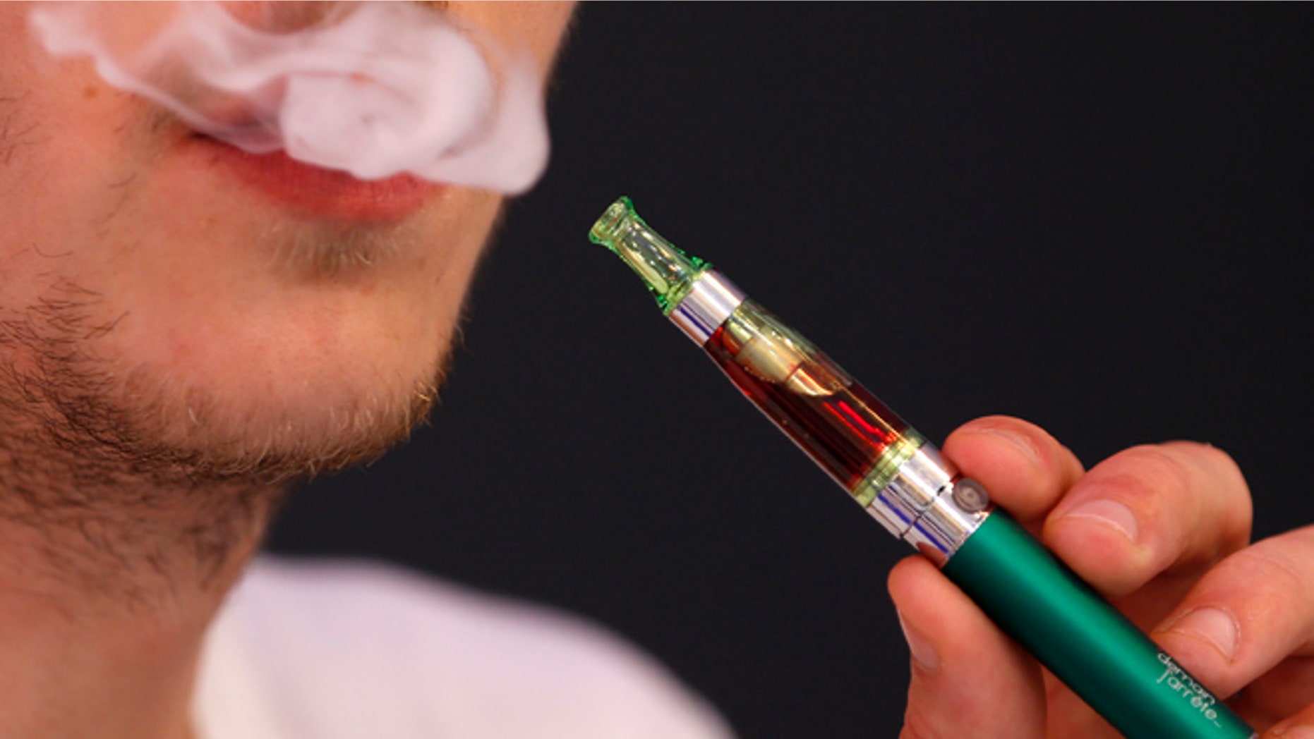 Martin Borne, co-founder of electronic cigarette retailer "Demain J'arrete", demonstrates the use of an electronic cigarette in his shop in Paris October 8, 2013. The European Parliament voted on Tuesday to water down proposed tobacco legislation, rejecting an immediate ban on menthol cigarettes and scaling down the size of health warnings on packets following intense lobbying by tobacco companies. The parliament also said manufacturers should be free to sell smokeless e-cigarettes, which deliver nicotine electronically and are a rapidly growing market, as a consumer product when not being marketed as an aide to help people quit smoking. REUTERS/Charles Platiau (FRANCE - Tags: SOCIETY HEALTH BUSINESS POLITICS) - RTX143QN