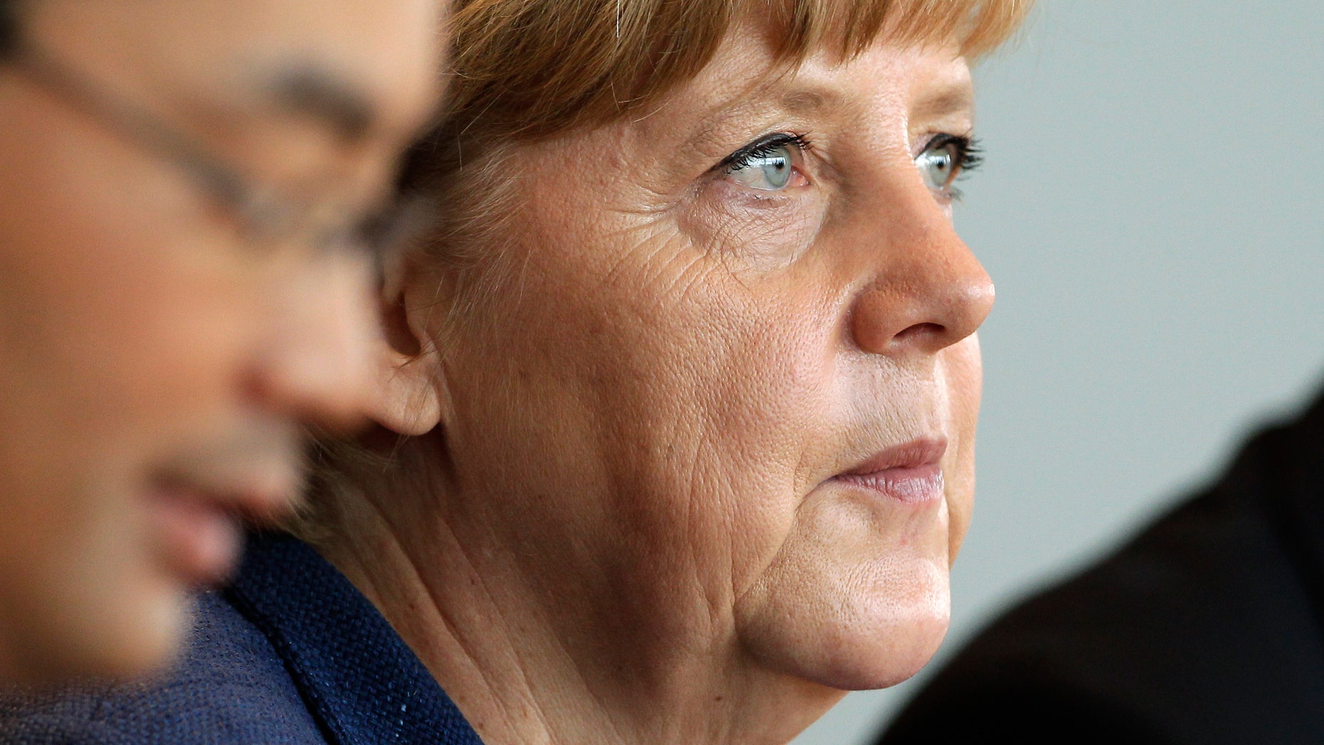 German Chancellor Angela Merkel attends the weekly cabinet meeting at the chancellery in Berlin, Germany, Wednesday, May 8, 2013. At left is German Economy Minister Philipp Roesler. (AP Photo/Michael Sohn)
