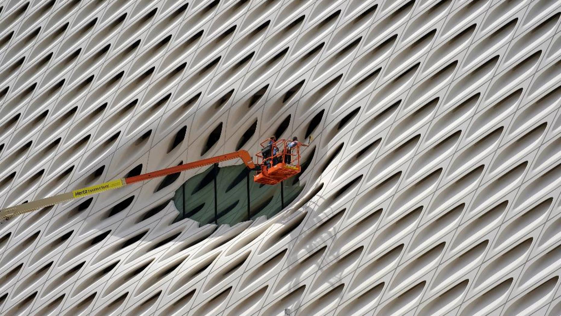 FILE - In this Sept. 1, 2015 file photo, workers clean the facade around a window of the new Broad Museum in downtown Los Angeles. The Conference Board releases its index of leading indicators for August on Friday, Sept. 18, 2015. (AP Photo/Richard Vogel, File)