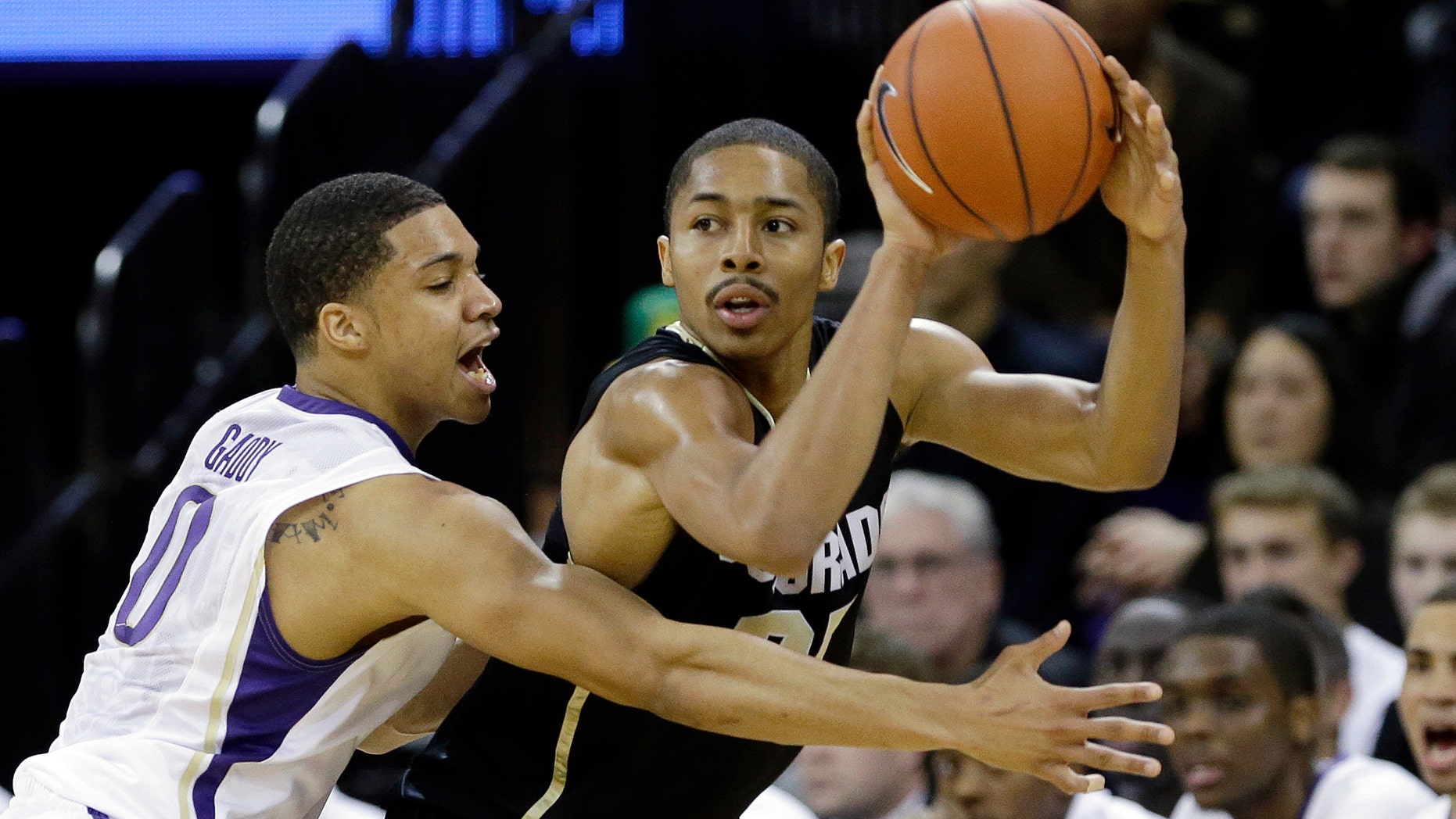 Colorado's Spencer Dinwiddie, right, is defended by Washington's Abdul Gaddy in the first half of an NCAA college basketball game Wednesday, Jan. 16, 2013, in Seattle. (AP Photo/Elaine Thompson)