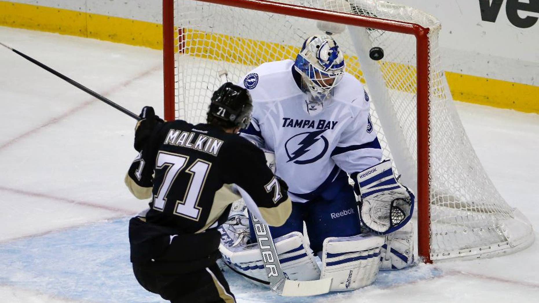 Pittsburgh Penguins' Evgeni Malkin (71) backhands a shot over Tampa Bay Lightning goalie Anders Lindback (39) for a goal in the third period of an NHL hockey game in Pittsburgh, Saturday, March 22, 2014. The Penguins won 4-3 in overtime. (AP Photo/Gene J. Puskar)