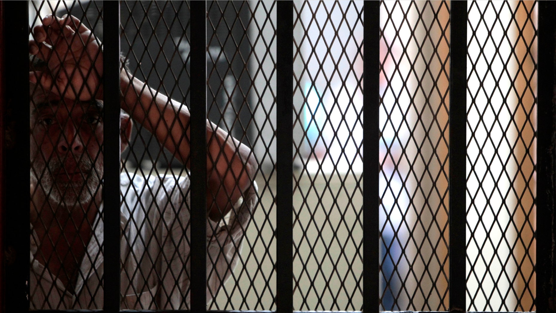 An inmate who survived a prison fire stands inside the medical attention area of the prison in Comayagua, Honduras, Honduras, early Thursday Feb. 16, 2012. A fire started by an inmate tore through the prison Tuesday night, killing over 300 people, according to officials. (AP Photo/Esteban Felix)