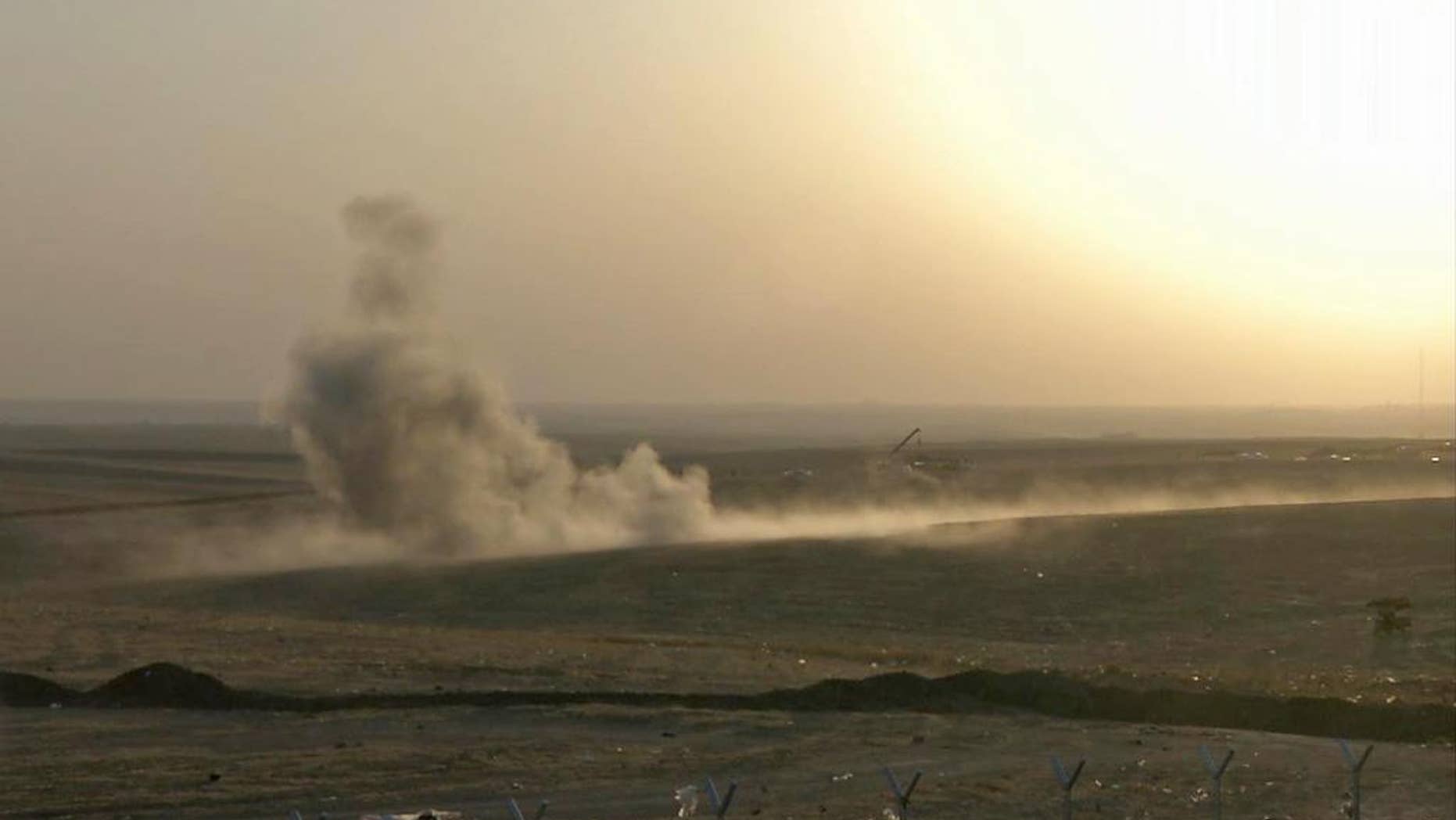This image made from AP video shows smoke rising from airstrikes targeting Islamic State militants near the Khazer checkpoint outside of the city of Irbil in northern Iraq, Friday, Aug. 8, 2014. The Iraqi Air Force has been carrying out strikes against the militants, and for the first time on Friday, U.S. war planes have directly targeted the extremist Islamic State group, which controls large areas of Syria and Iraq.(AP Photo via AP video)