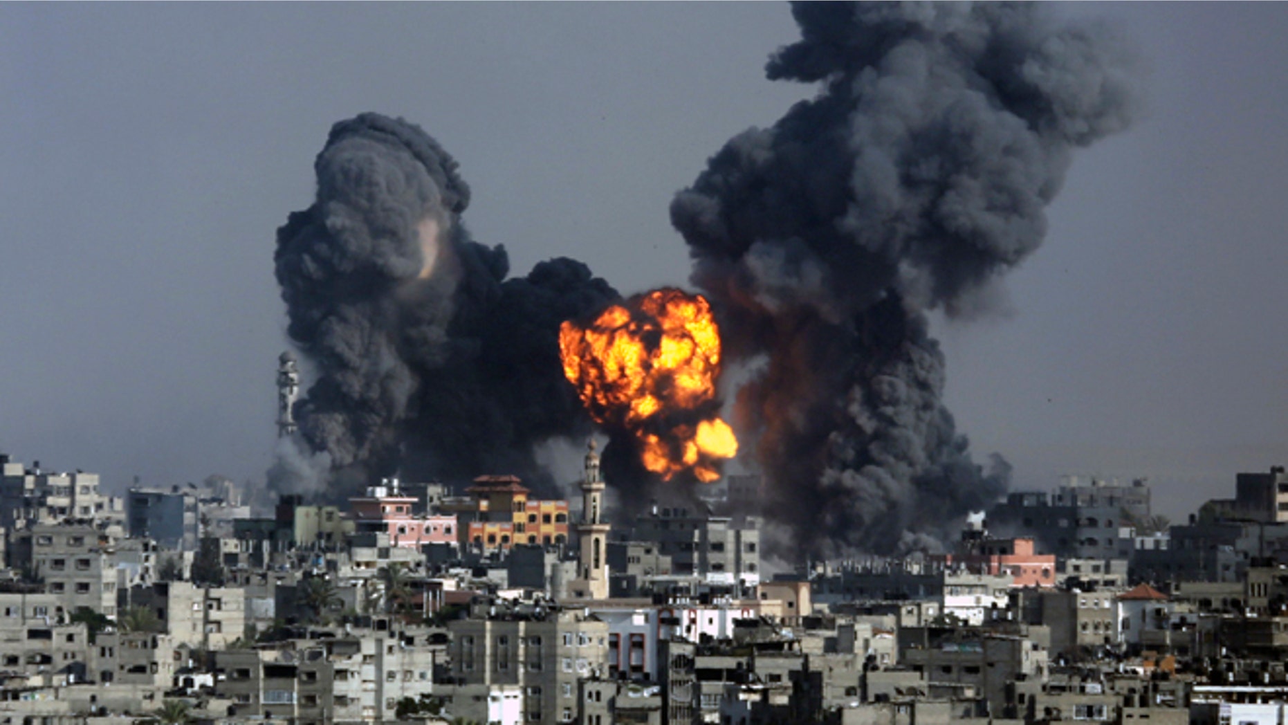 Smoke and fire from the explosion of an Israeli strike rise over Gaza City, Tuesday, July 22, 2014, as Israeli airstrikes pummeled a wide range of locations along the coastal area and diplomatic efforts intensified to end the two-week war. Disagreement over whether to lift the Gaza blockade is a key stumbling block to ending more than two weeks of fighting between the Islamic militant Hamas and Israel. Some in Gaza say they would rather endure more fighting than return to life under the blockade. (AP Photo/Hatem Moussa)