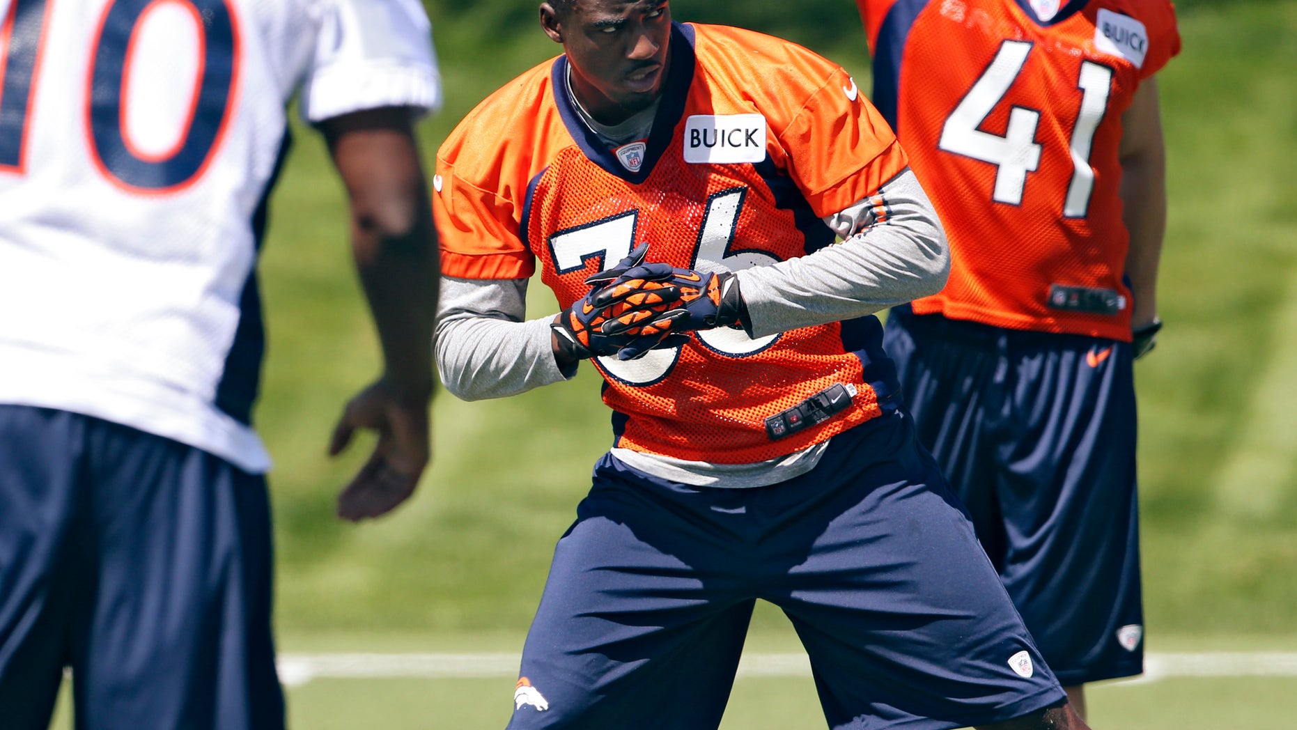 Denver Broncos cornerback Kayvon Webster (36) stretches with teammates Gerell Robinson (10) and Ross Rasner (41) during NFL football rookie minicamp at the team's training facility in Englewood, Colo., Saturday, May 11, 2013. (AP Photo/Ed Andrieski)