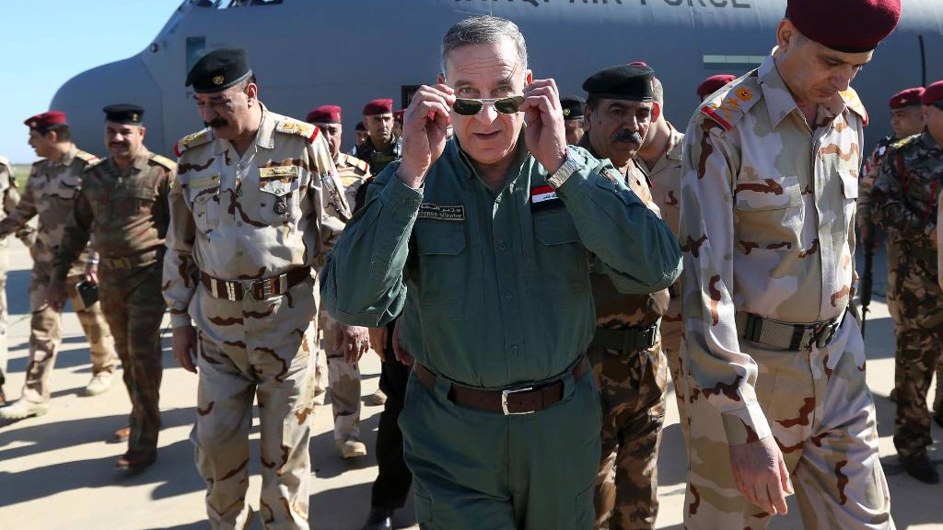 FILE - In this Wednesday, March 9, 2016 file photo, Iraqi Defense Minister Khaled al-Obeidi, center, arrives at a military a base outside Tikrit, 130 kilometers (80 miles) north of Baghdad, Iraq. Al-Obeidi has received a no-confidence vote from parliament just as Iraqi forces retook a key northern town near the Islamic State-held city of Mosul on Thursday, Aug. 25, 2016. He is the first sitting defense minister to receive a no confidence vote from parliament since the overthrow of former Iraqi leader Saddam Hussein in 2003. (AP Photo/Hadi Mizban, File)