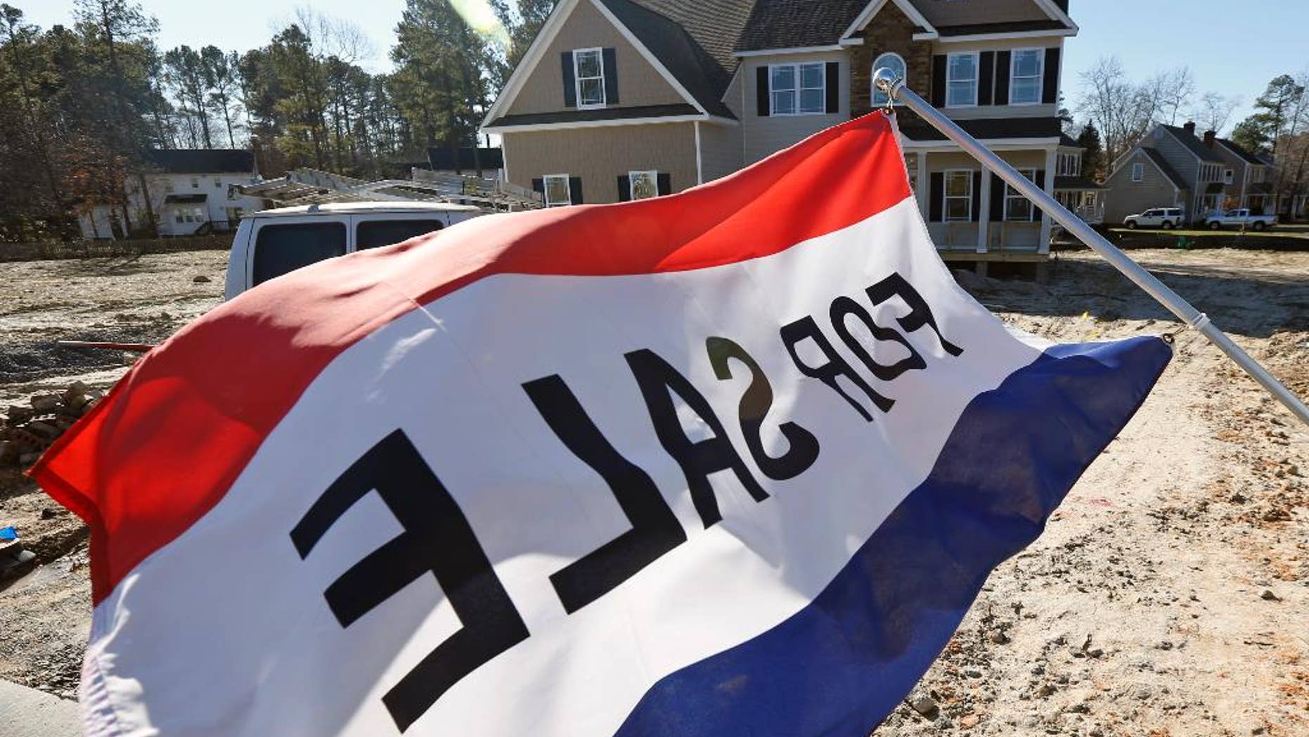 In this Jan. 8, 2015 photo, a flag advertising a new home for sale flaps in the breeze in Richmond, Va. The Commerce Department reports on U.S. sales of new homes in January on Wednesday, Feb. 25, 2015. (AP Photo/Steve Helber)
