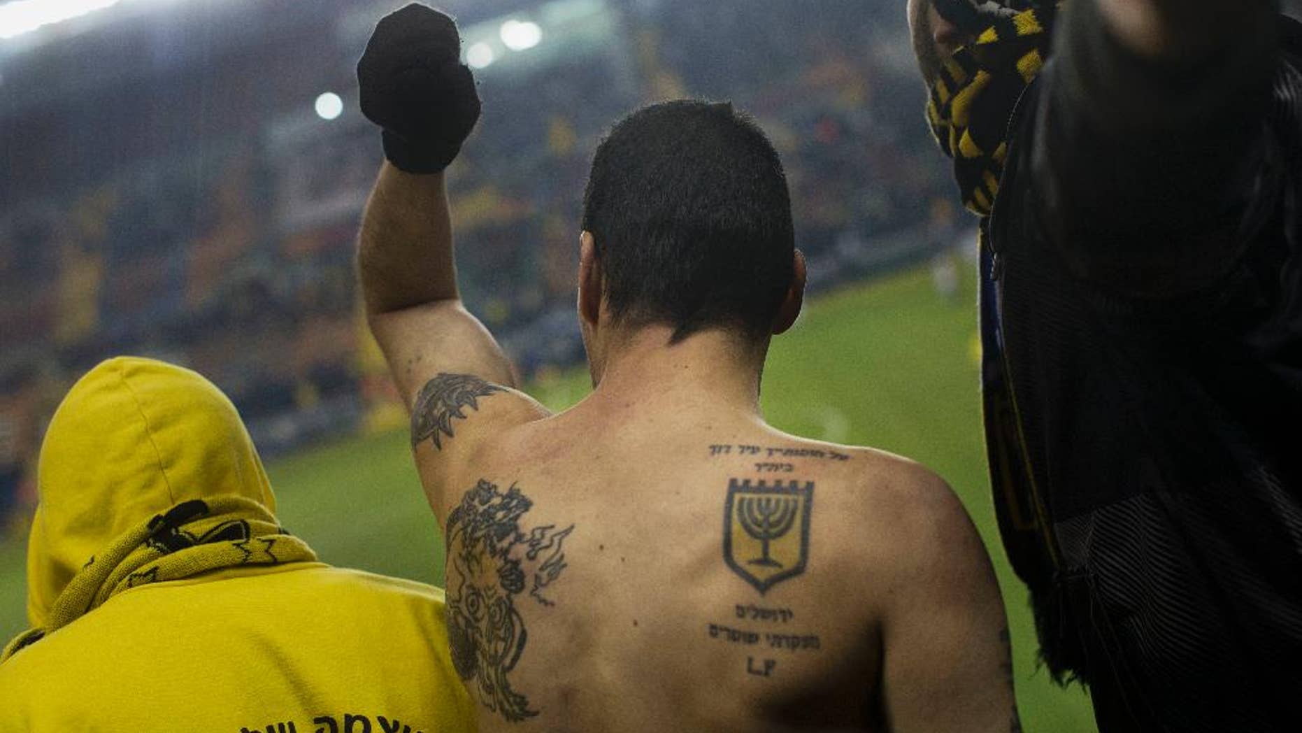 In this Tuesday, Jan. 29, 2013 file photo, Beitar Jerusalem F.C. soccer supporters watch a State Cup soccer match against Maccabi Umm al-Fahm F.C. at the Teddy Stadium in Jerusalem. Israeli police say they have arrested dozens of members of an extremist soccer fans' group. Police spokeswoman Luba Samri said on Tuesday, July 26, 2016 that 56 suspected members of the "La Familia" group of Beitar Jerusalem fans were arrested in an overnight raid. (AP Photo/Bernat Armangue, File)