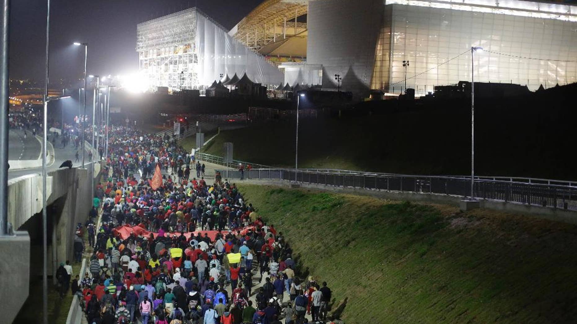 Members of the Homeless Workers Movement march in front of Arena Corinthians stadium during a protest demanding better public services and against the money spent on the World Cup preparations in Sao Paulo, Brazil, Wednesday, June 4, 2014. (AP Photo/Nelson Antoine)