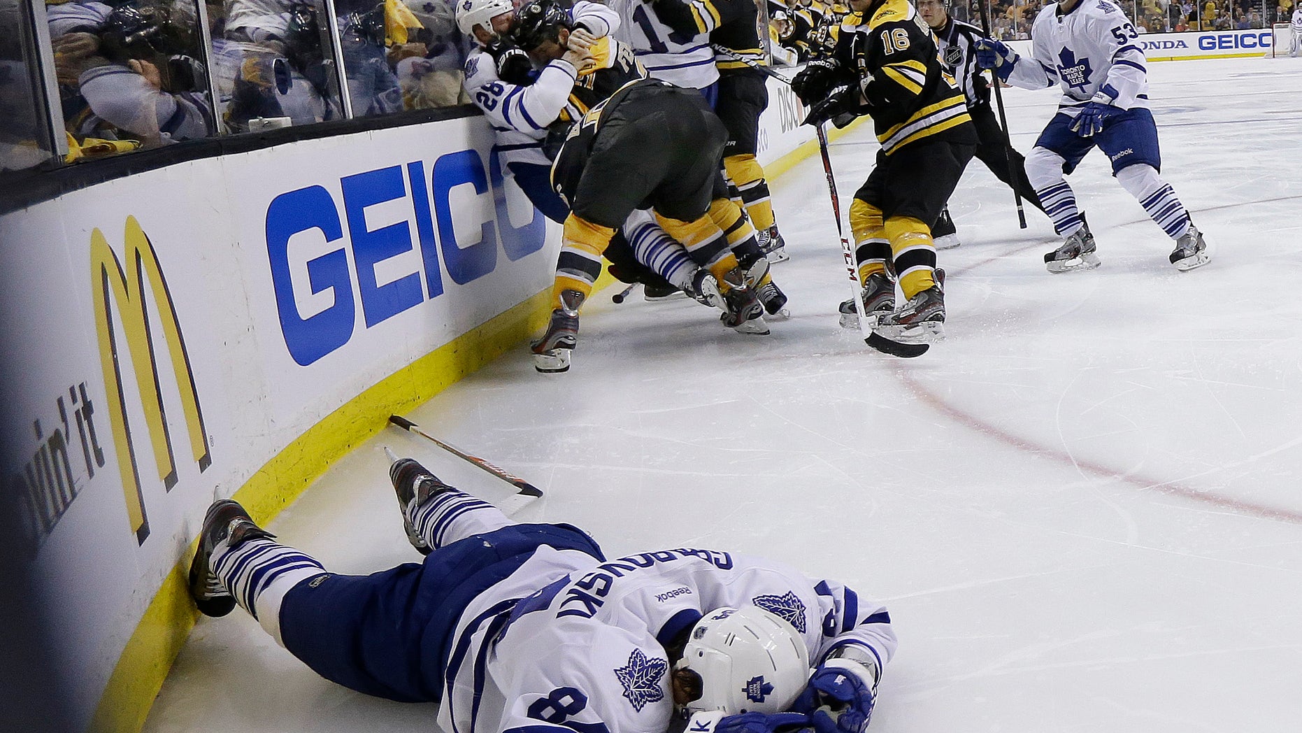 Toronto Maple Leafs center Mikhail Grabovski (84) lies on the ice after a hard hit as Boston Bruins and Maple Leafs players grapple behind during the third period in Game 1 of a first-round NHL hockey playoff series in Boston, Wednesday, May 1, 2013. (AP Photo/Elise Amendola)
