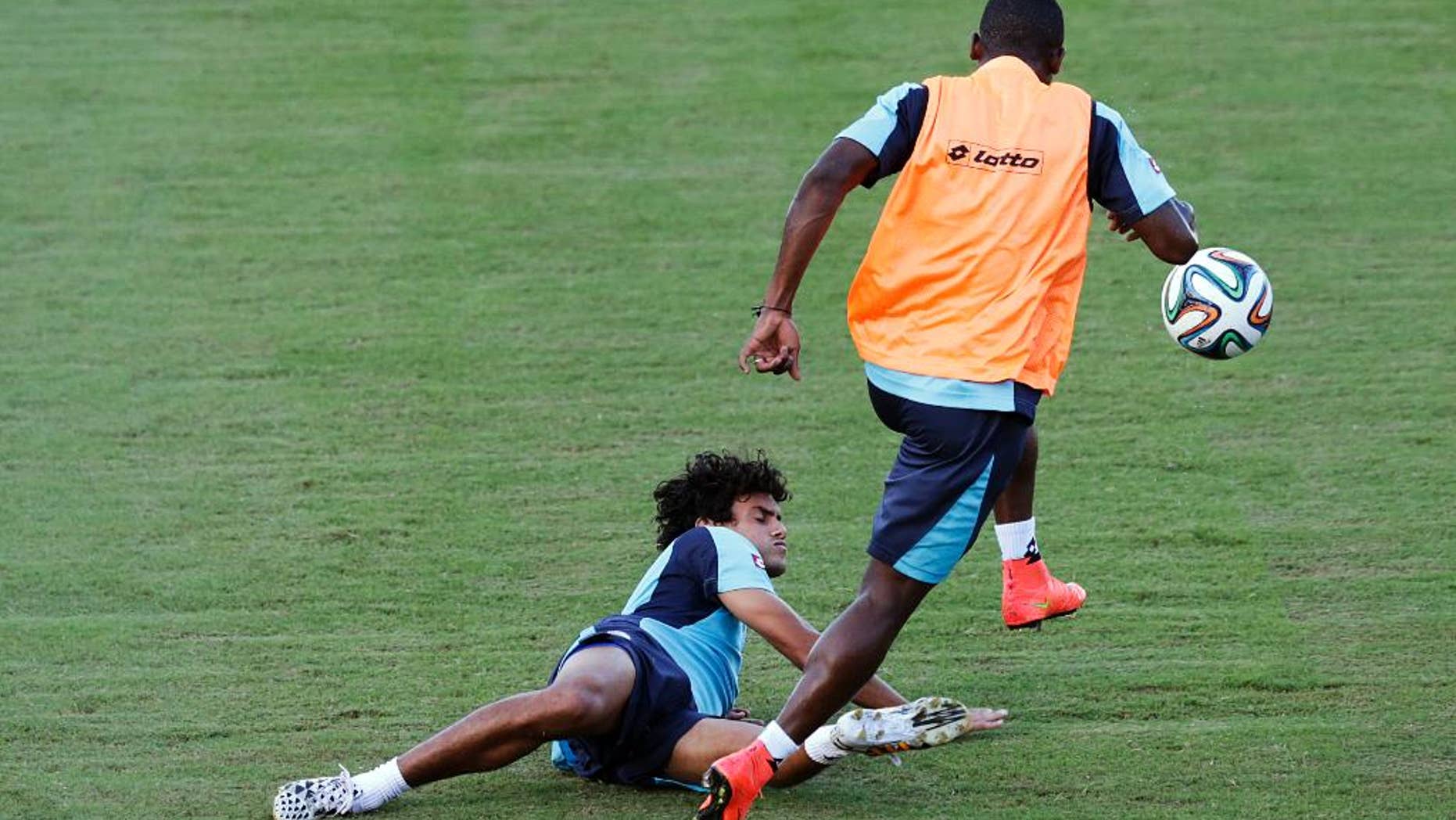 Costa Rica's Yeltsin Tejeda falls as he is tackled during a training session in Salvador, Brazil, Friday, July 4, 2014. Costa Rica play their quarterfinal match of the 2014 World Cup soccer tournament against Netherlands on July 5 in Salvador(AP Photo/Wong Maye-E)