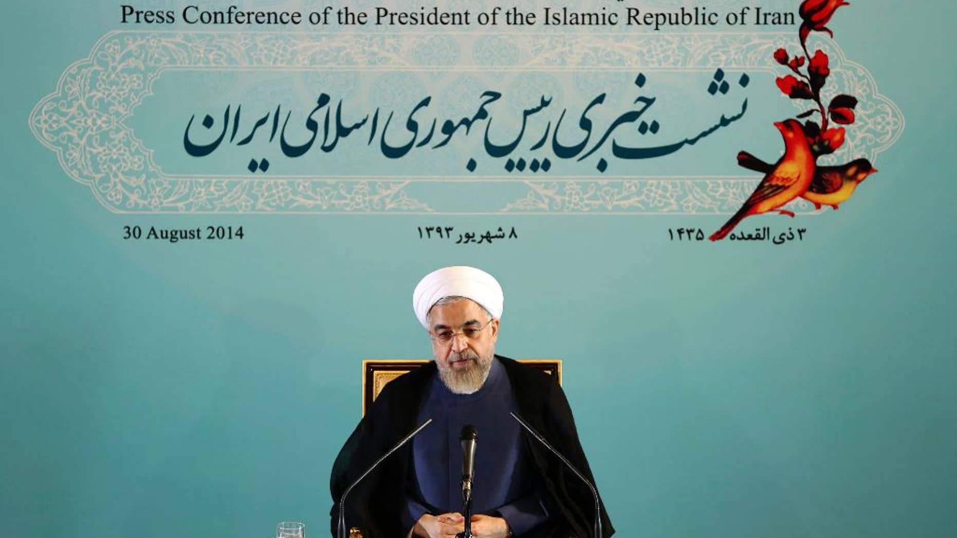 Iranian President Hassan Rouhani gives a press conference in Tehran, Iran, Saturday, Aug. 30, 2014. Rouhani called Western sanctions an "invasion" on Saturday after Washington imposed existing sanctions on more than 25 businesses, banks and individuals suspected of working to expand Iran's nuclear program, support terrorism and help Iran evade U.S. and international sanctions. Iran's state TV also said the move violated an interim agreement reached with world powers under which Western nations agreed to ease sanctions in exchange for Iran curbing its nuclear activities. However, Friday's action did not constitute an expansion of the sanctions regime. (AP Photo/Ebrahim Noroozi)