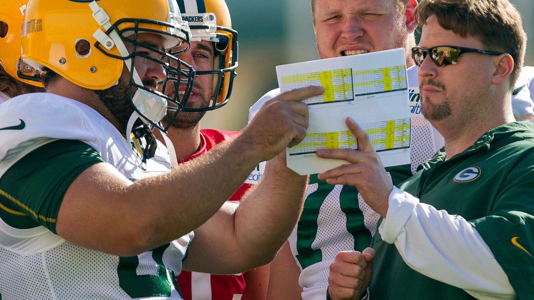 FILE - in this July 28, 2012, file photo, Green Bay Packers quarterbacks coach Ben McAdoo, right, center Jeff Saturday (63), quarterback Aaron Rodgers (12) and offensive guard T.J. Lang (70) talk during NFL football training camp in Green Bay, Wis. The New York Giants on Tuesday, Jan. 14, 2014, hired McAdoo as their new offensive coordinator. (AP Photo/Mike Roemer, File)